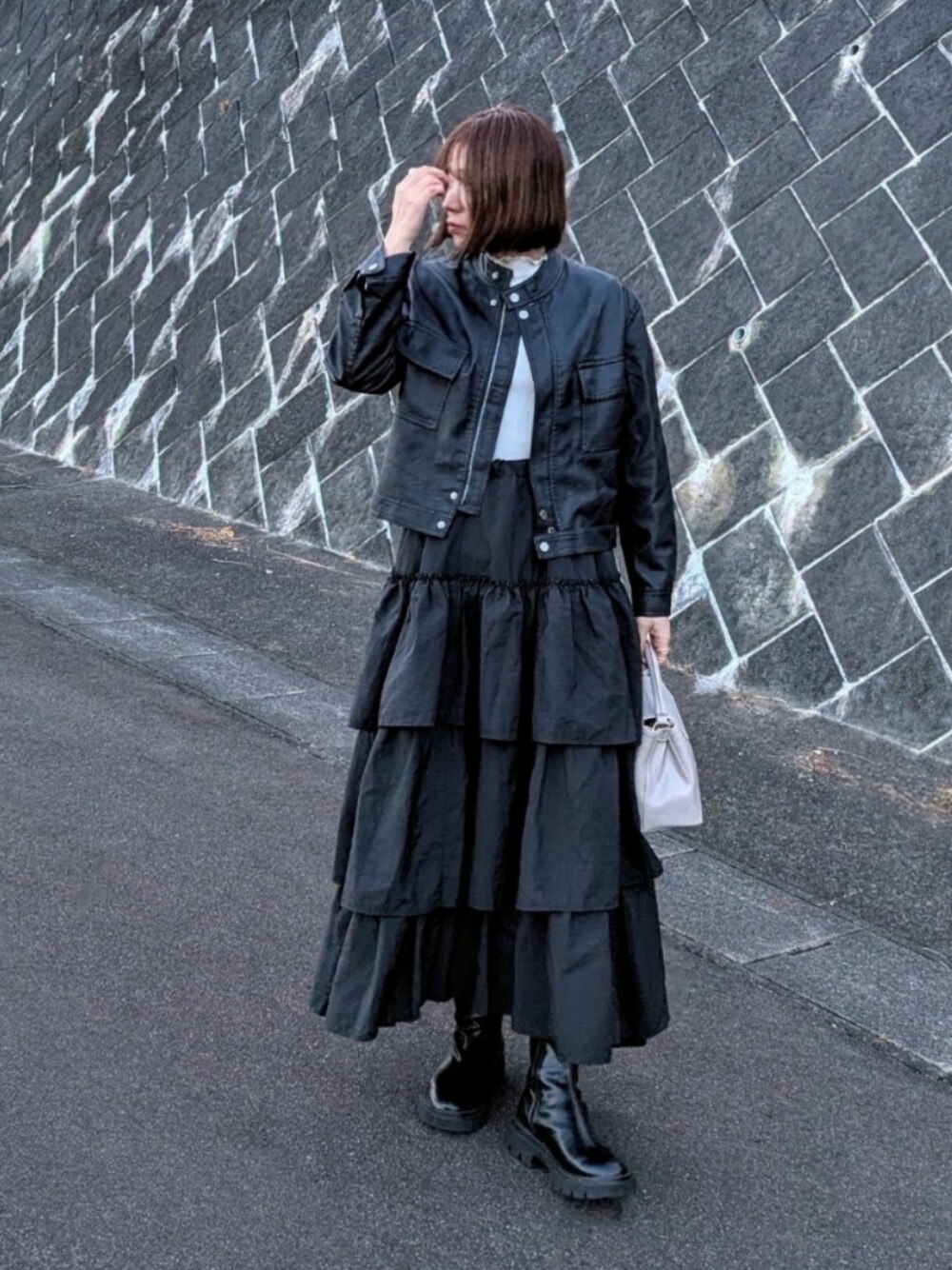ブラック系のブルゾン、ブラック系のスカート、ホワイト系のTシャツ/カットソーを着用したレディースの冬コーディネートの1枚目の写真