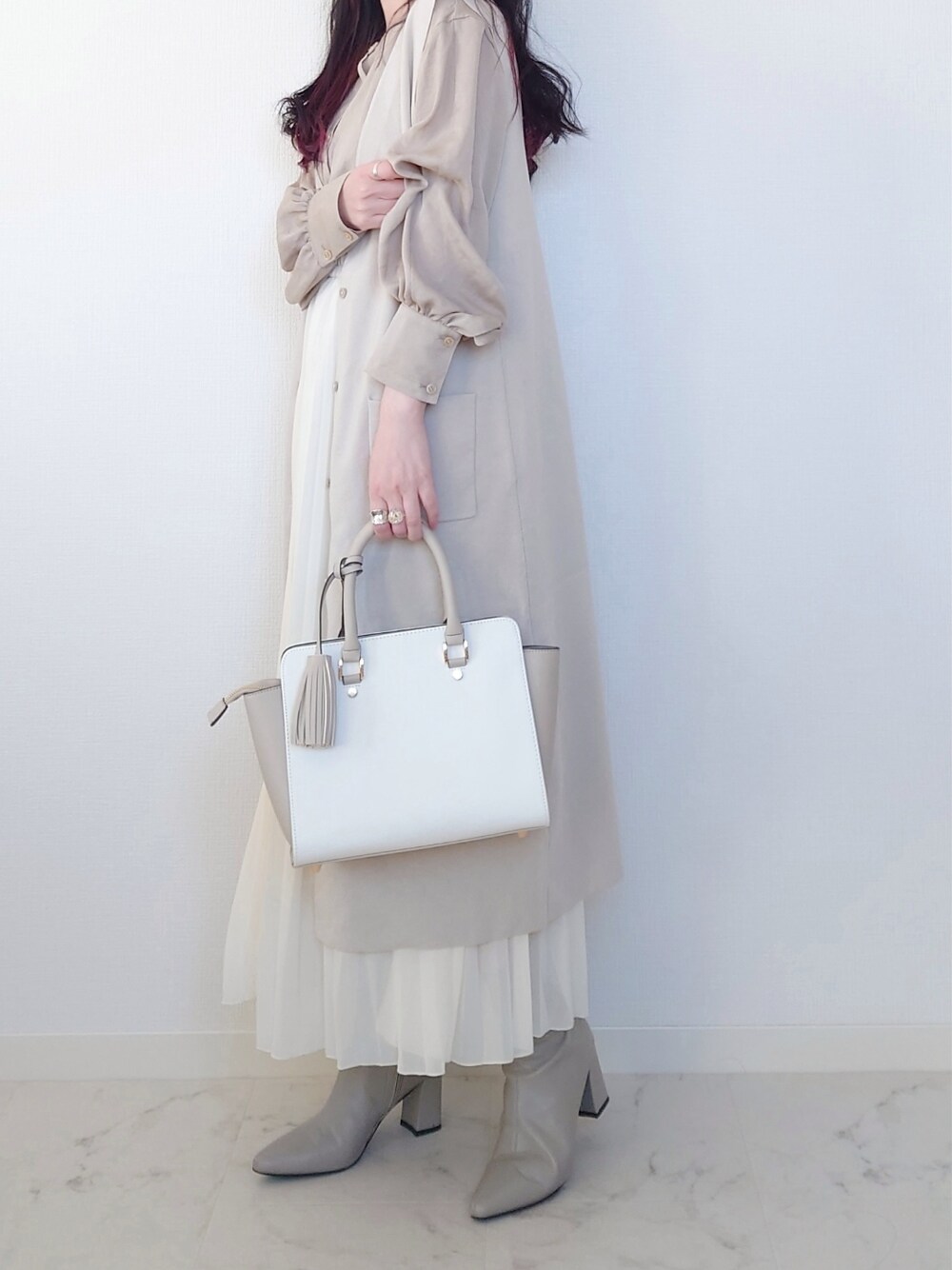 グレー系のブーツ、グレー系のビジネスバッグ、ブルー系のシャツ/ブラウスを着用したレディースの冬コーディネートの3枚目の写真