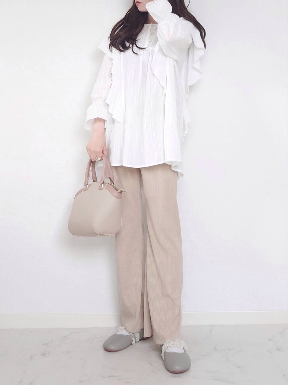 ベージュ系のその他パンツ、ホワイト系のシャツ/ブラウス、グリーン系のパンプスを着用したレディースの冬コーディネートの3枚目の写真