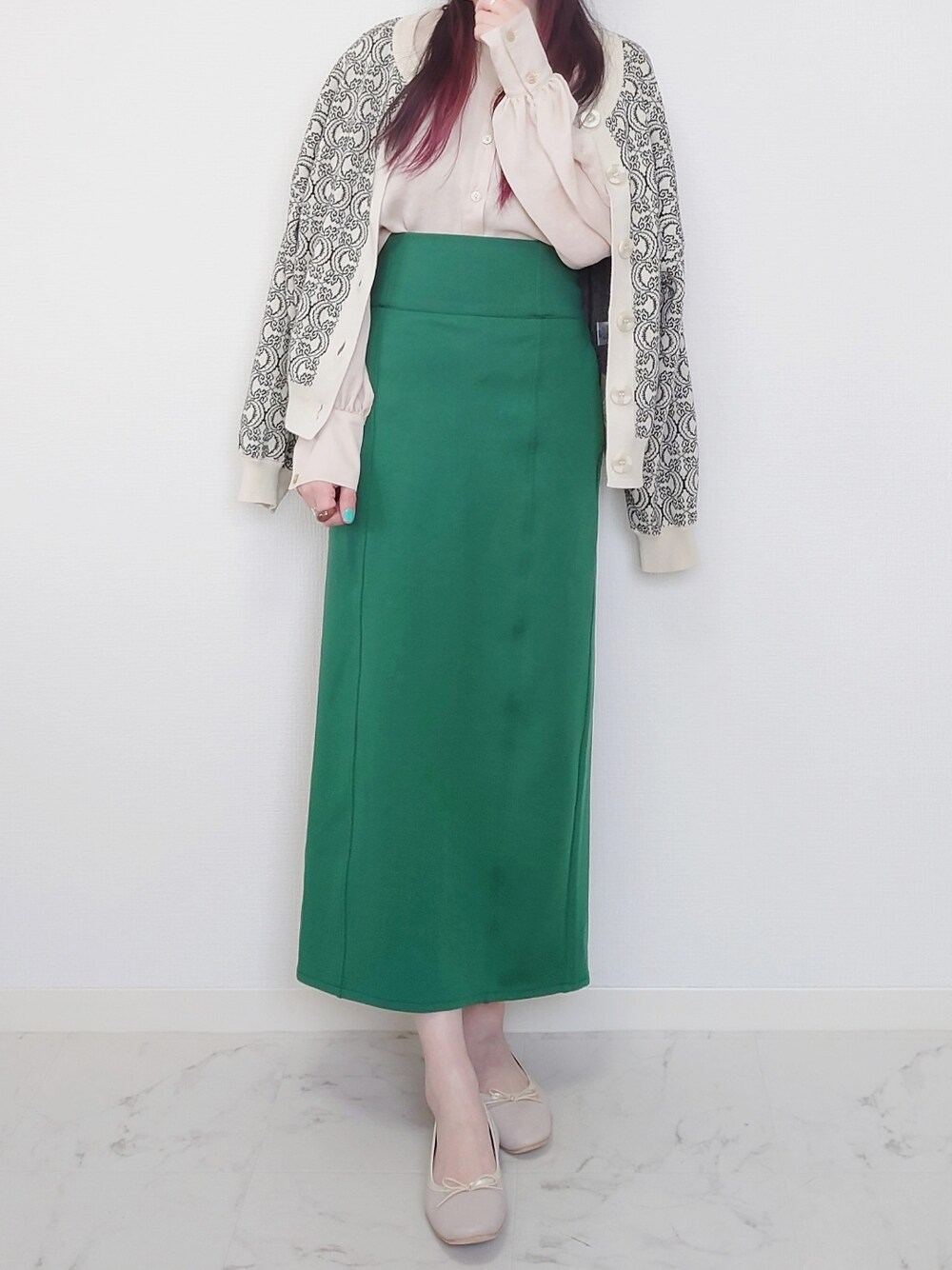 ホワイト系のカーディガン/ボレロ、グリーン系のスカート、ブラウン系のスカートを着用したレディースの春コーディネートの2枚目の写真