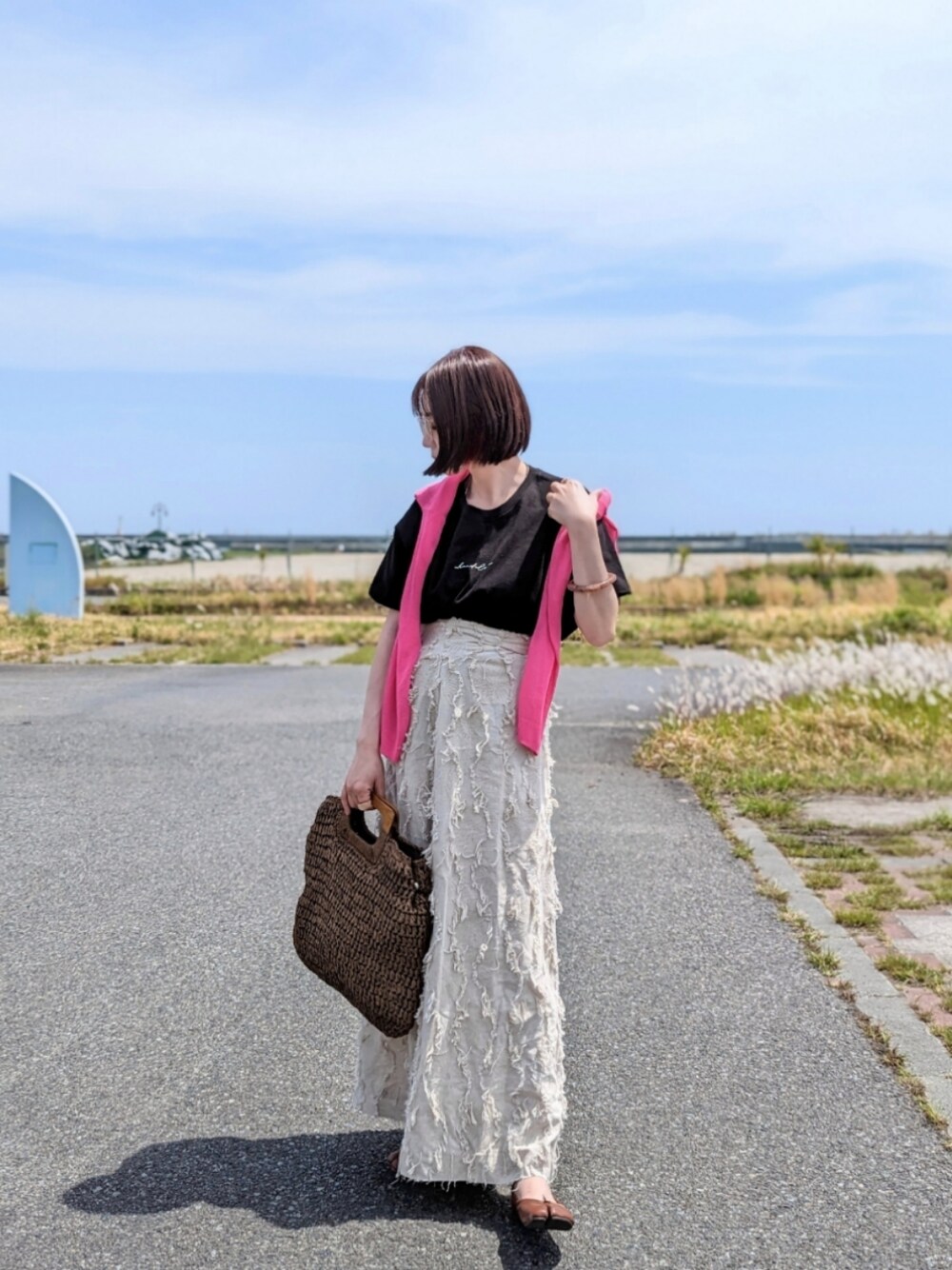 ブラック系のTシャツ/カットソー、ホワイト系のスカート、ピンク系のカーディガン/ボレロを着用したレディースの春コーディネートの1枚目の写真