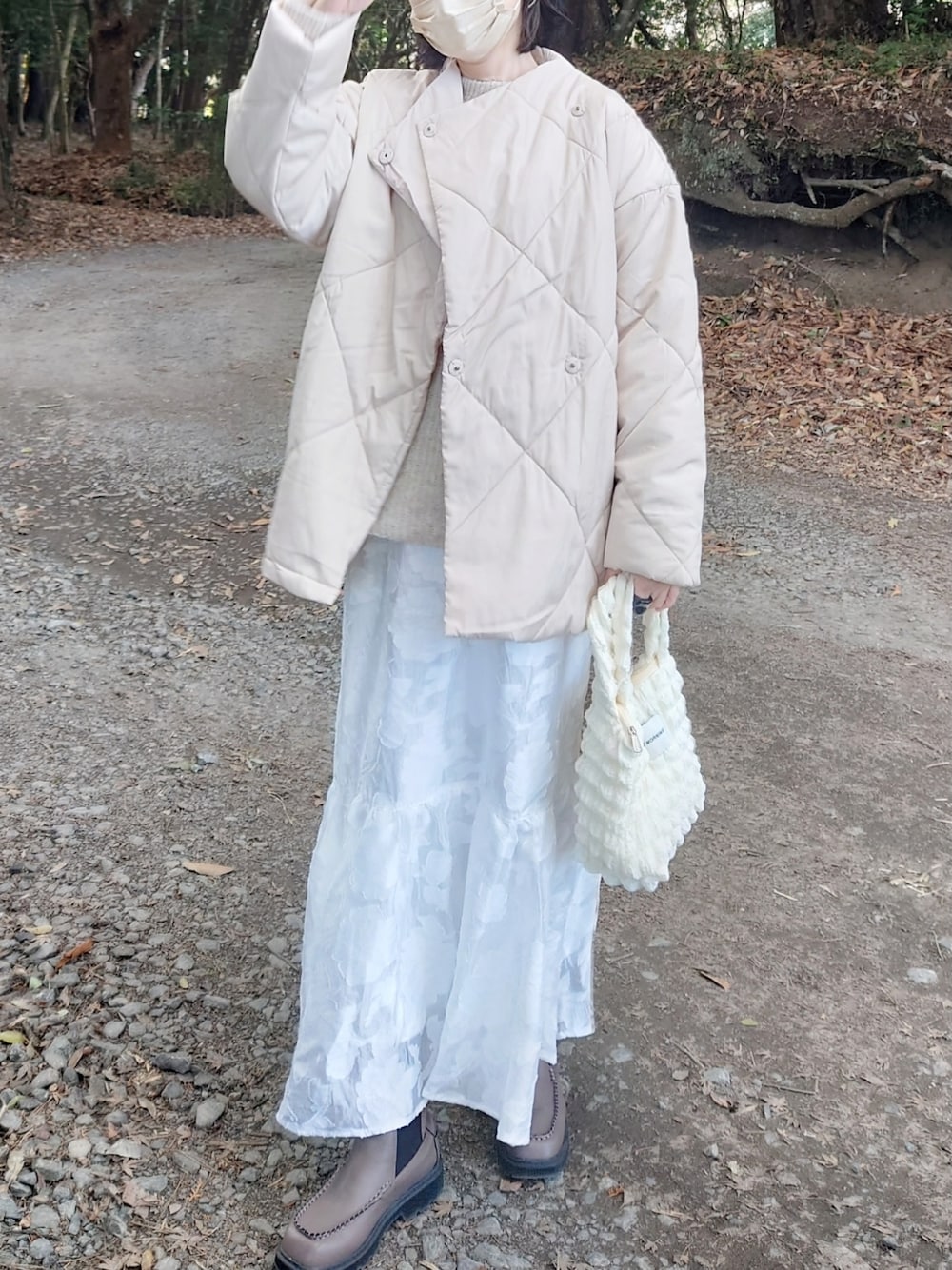 ホワイト系のダウンジャケット/コート、ホワイト系のニット/セーター、ホワイト系のスカートを着用したレディースの冬コーディネートの1枚目の写真
