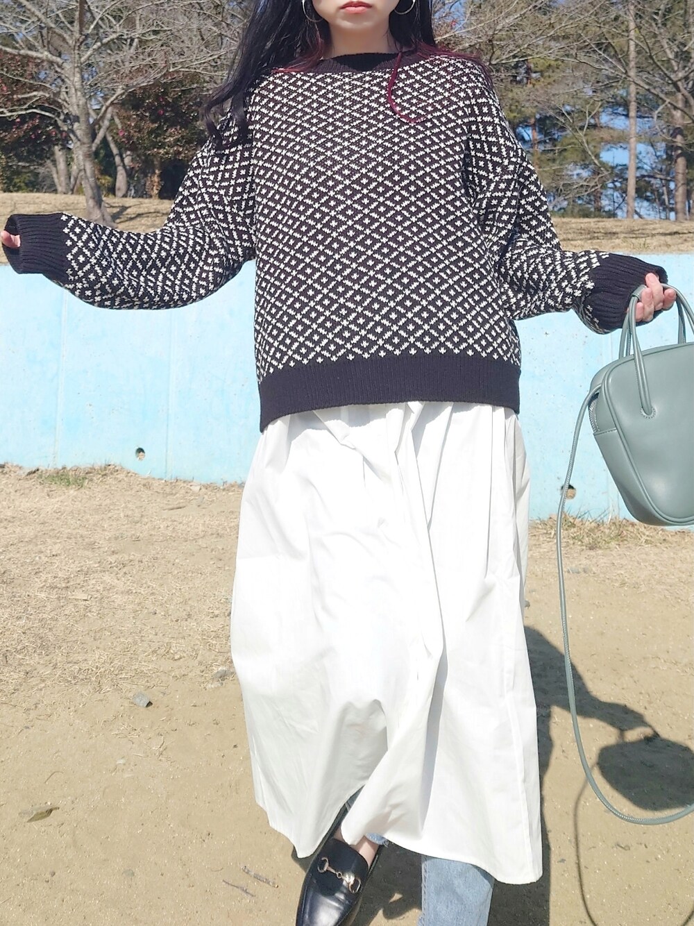 ブラック系のその他トップス、ホワイト系のワンピース/ドレス、グリーン系のショルダーバッグを着用したレディースの冬コーディネートの2枚目の写真