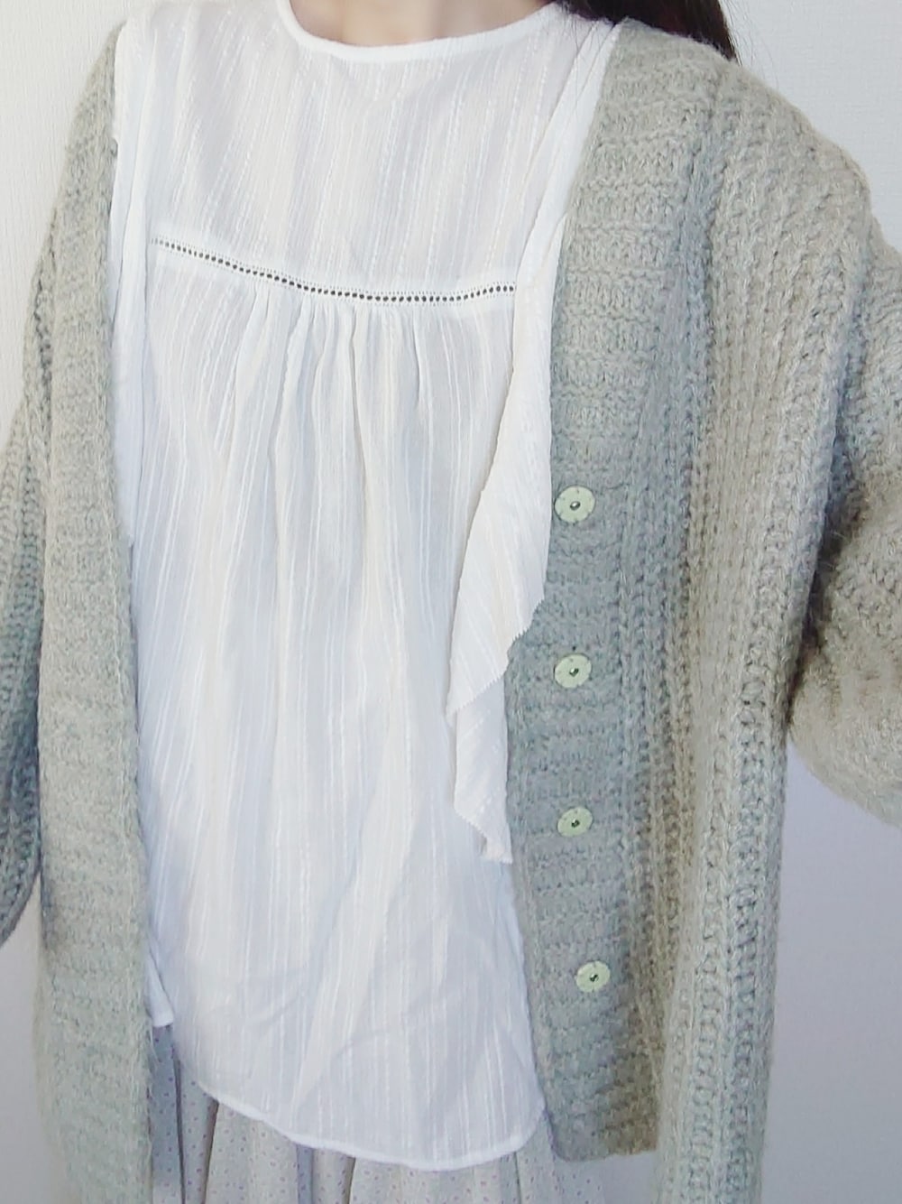 グリーン系のカーディガン/ボレロ、ホワイト系のシャツ/ブラウス、グリーン系のスカートを着用したレディースの春コーディネートの3枚目の写真