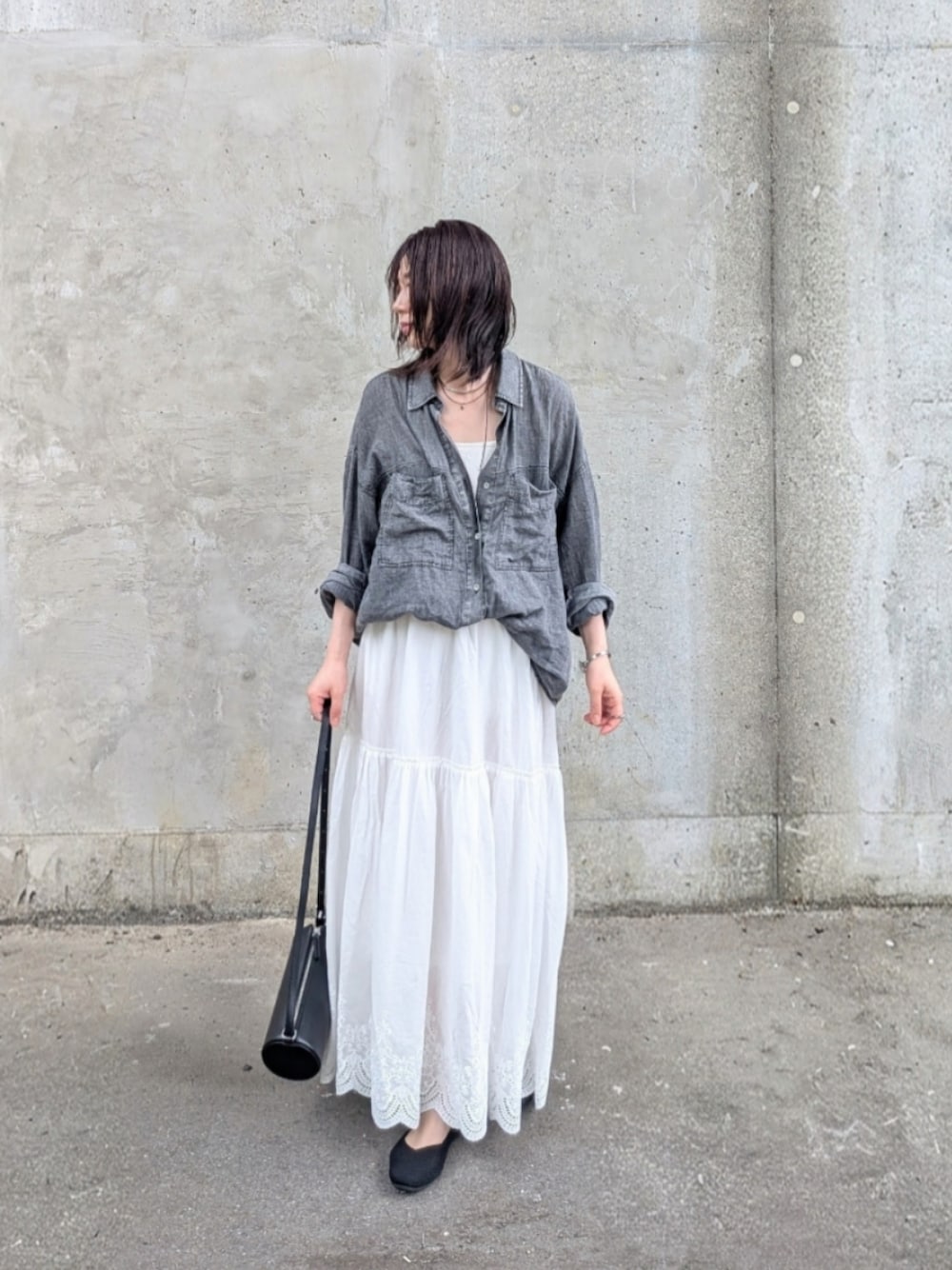 ホワイト系のスカート、ブラック系のシャツ/ブラウス、ブラック系のパンプスを着用したレディースの夏コーディネートの1枚目の写真