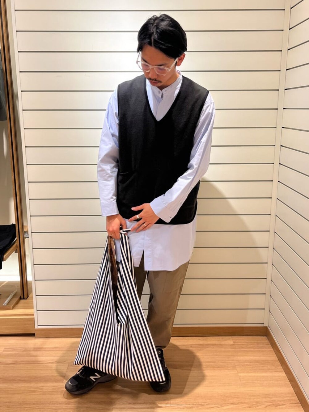 グレー系のベスト、ブルー系のシャツ/ブラウス、ベージュ系のチノパンツを着用したメンズの春コーディネートの1枚目の写真