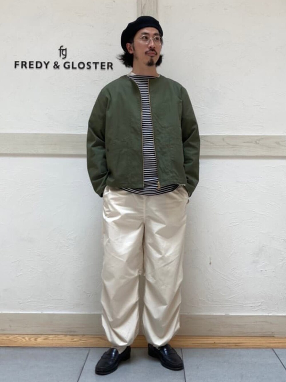 ブラック系のTシャツ/カットソー、グリーン系のブルゾン、ホワイト系のその他パンツを着用したメンズの春コーディネートの1枚目の写真