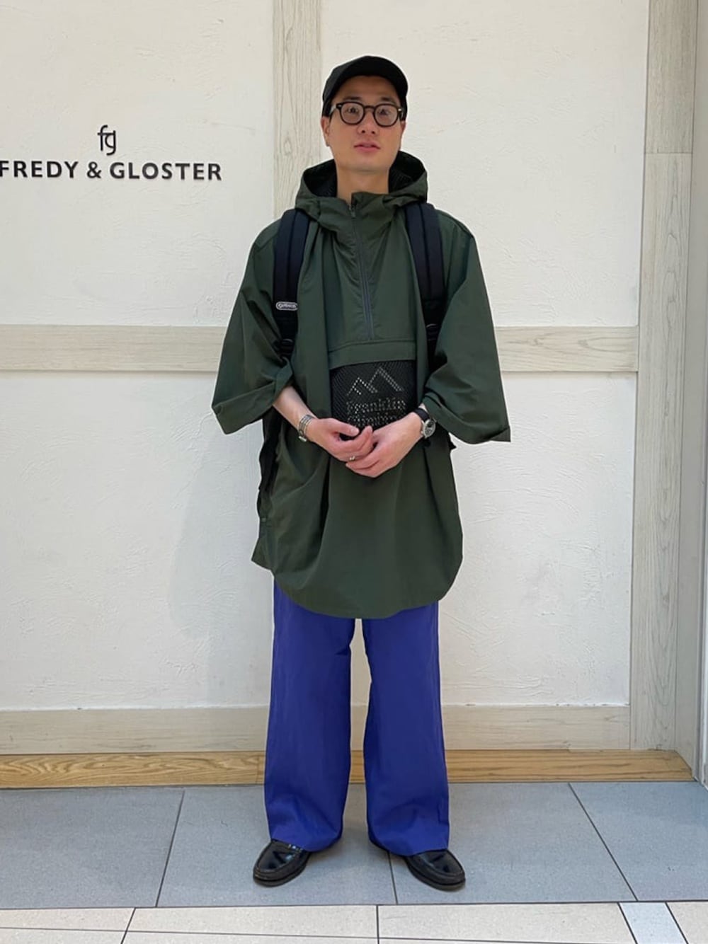 「FREDY&GLOSTER、gloster、フレディアンドグロスター、夏コーデ、メンズコーデ、ポンチョ、アウトドアスタイル、リュック、カラーパンツ、大人コーデ、革靴、カラー×コーデ、メガネ男子、メンズライク、ラフコーデ」｜「Franklin Climbingの【Franklin Climbing/フランクリンクライミング】リバーポンチョ（ポンチョ、グリーン系）」を使った、GLOSTER stylingさん（メンズ・173cm）の夏コーディネートの1枚目の写真
