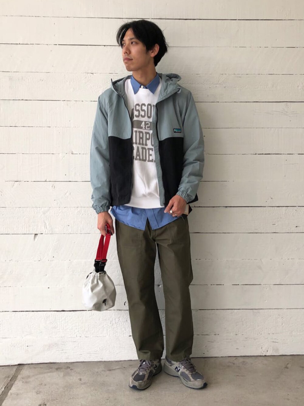 グレー系のマウンテンパーカー、ホワイト系のスウェット、グリーン系のその他パンツを着用したメンズの春コーディネートの1枚目の写真