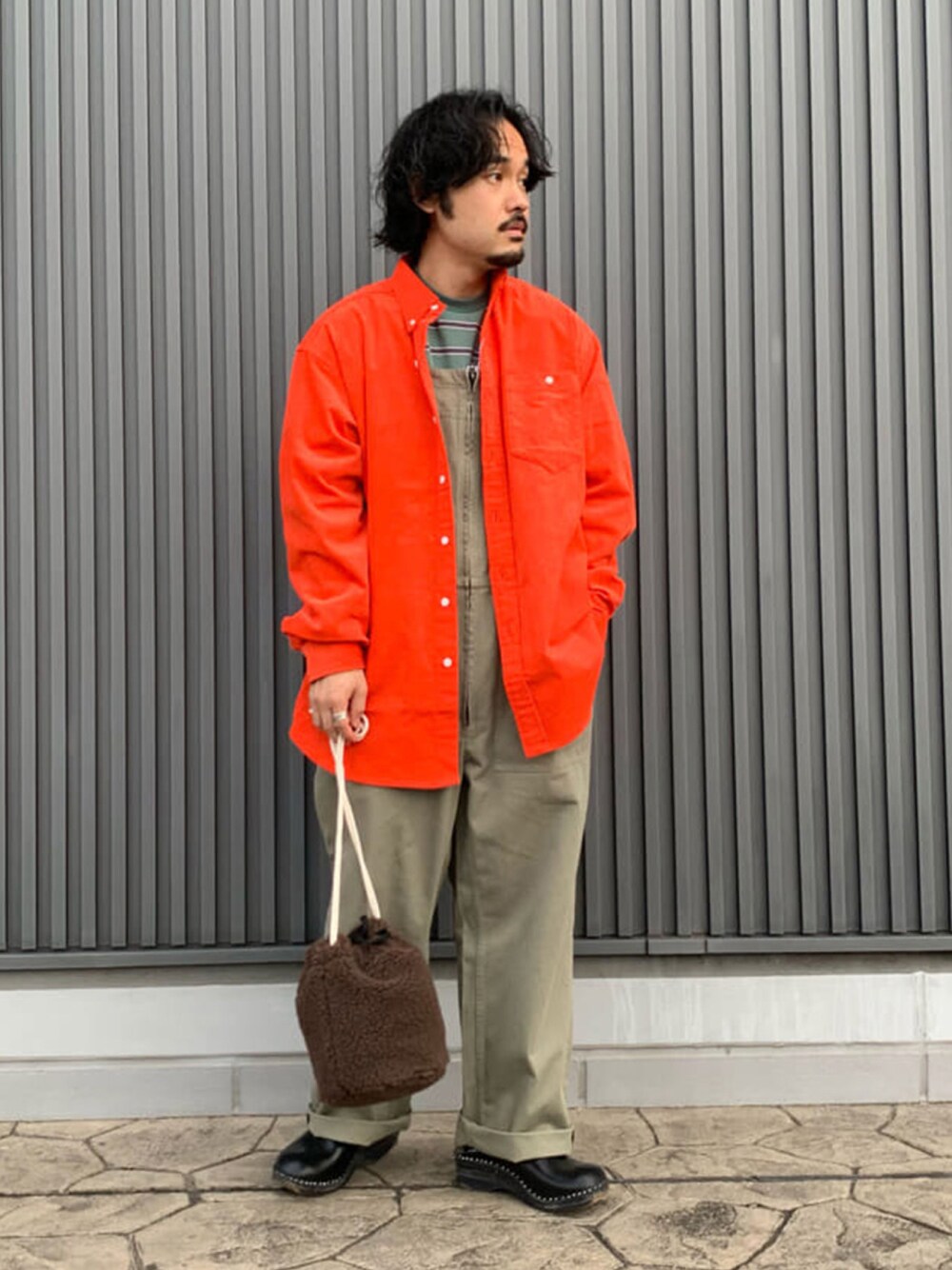 オレンジ系のシャツ/ブラウス、グリーン系のTシャツ/カットソー、ブラウン系のショルダーバッグを着用したメンズの秋コーディネートの1枚目の写真