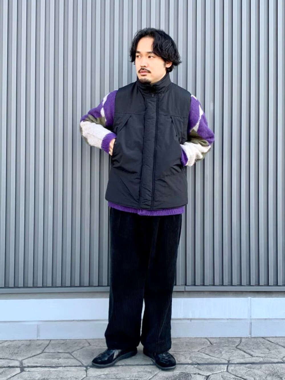 ブラック系のダウンベスト、パープル系のニット/セーターを着用したメンズの冬コーディネートの1枚目の写真