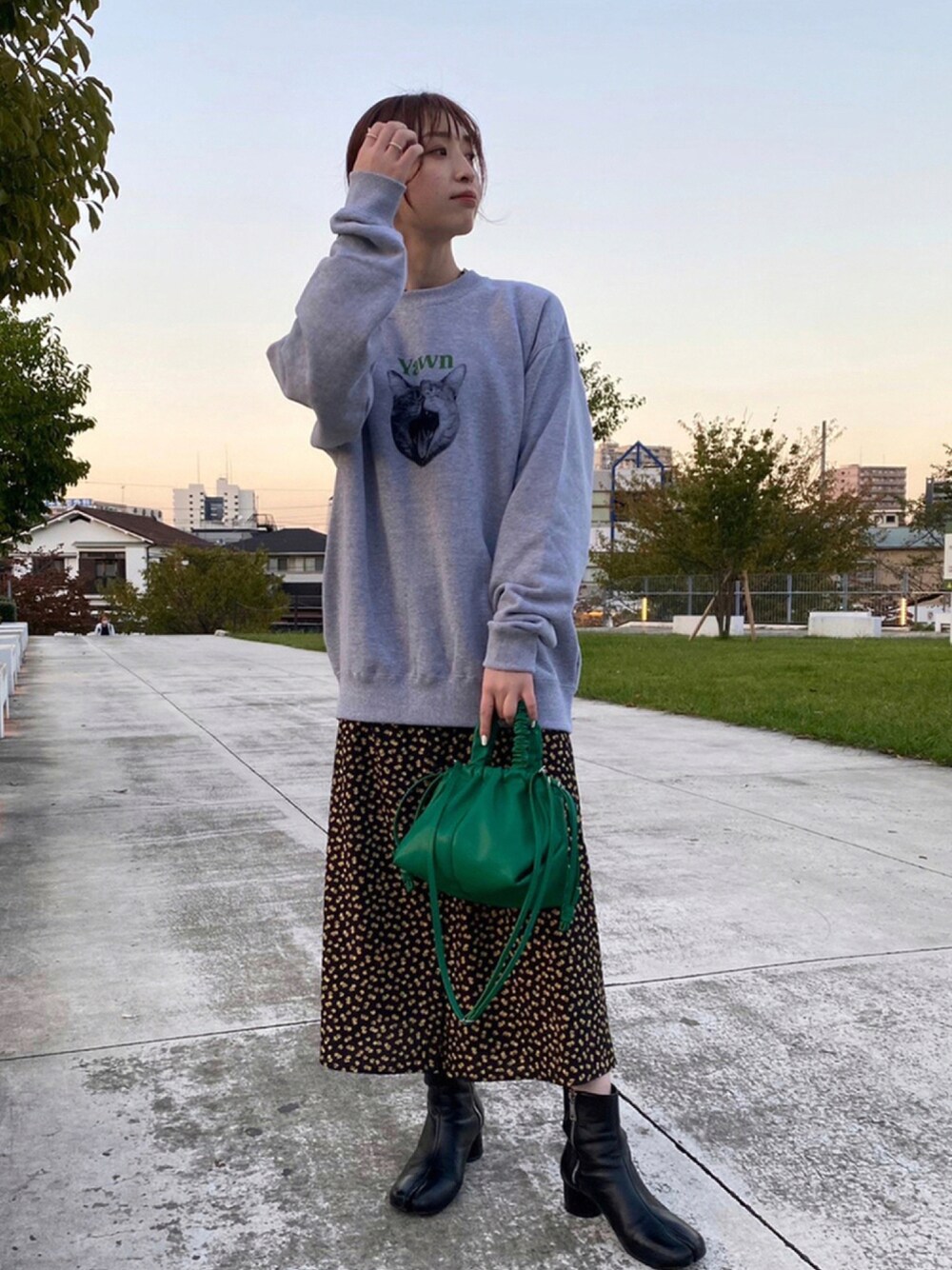 グレー系のスウェット、グリーン系のトートバッグを着用したレディースの秋コーディネートの1枚目の写真