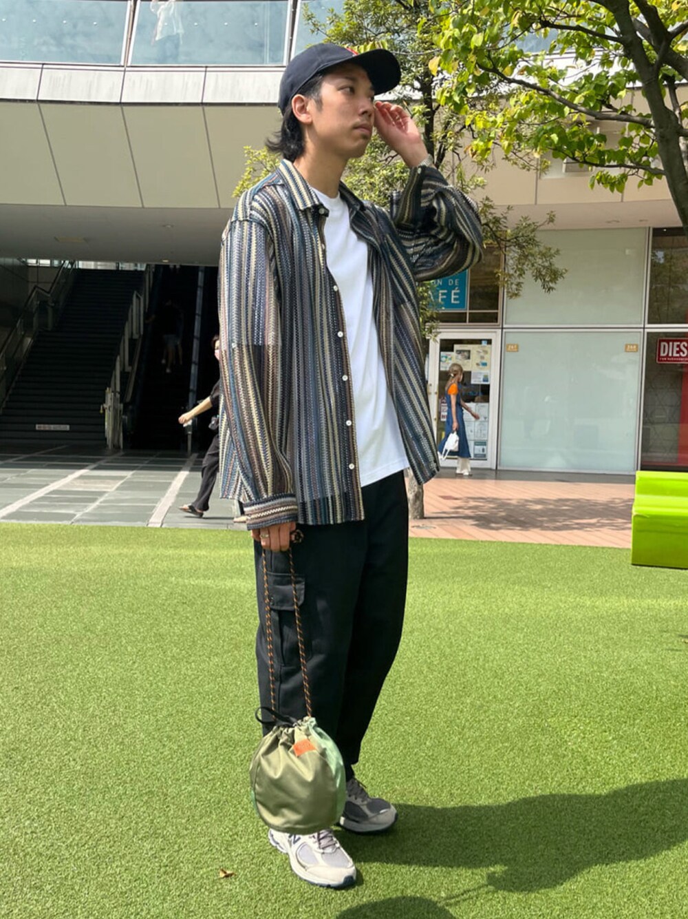 ブルー系のシャツ/ブラウス、ホワイト系のTシャツ/カットソー、グリーン系のショルダーバッグを着用したメンズの秋コーディネートの1枚目の写真