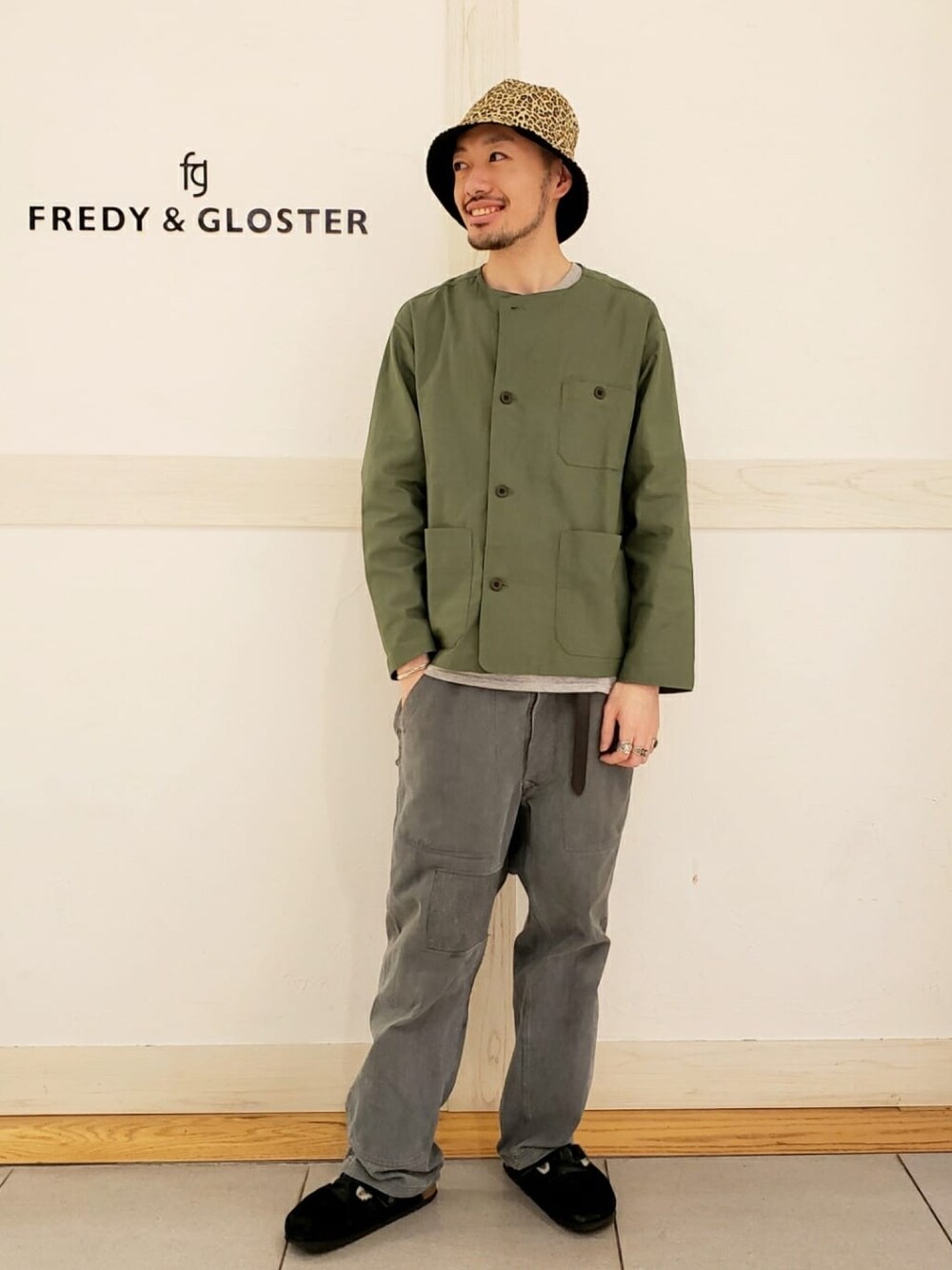 グリーン系のブルゾン、ブラック系のハットを着用したメンズの春コーディネートの1枚目の写真