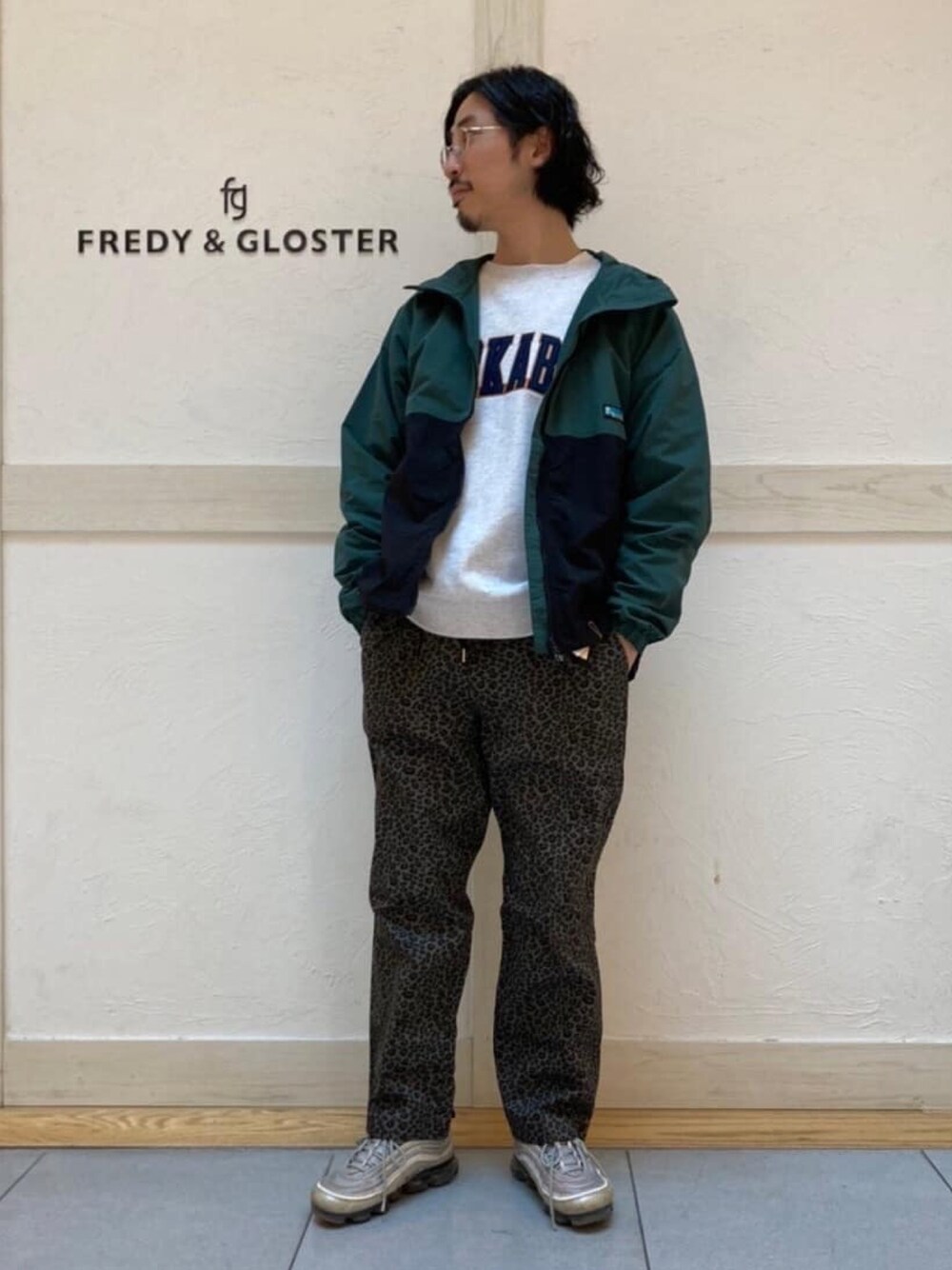 グリーン系のマウンテンパーカー、ブラック系のその他パンツを着用したメンズの春コーディネートの1枚目の写真