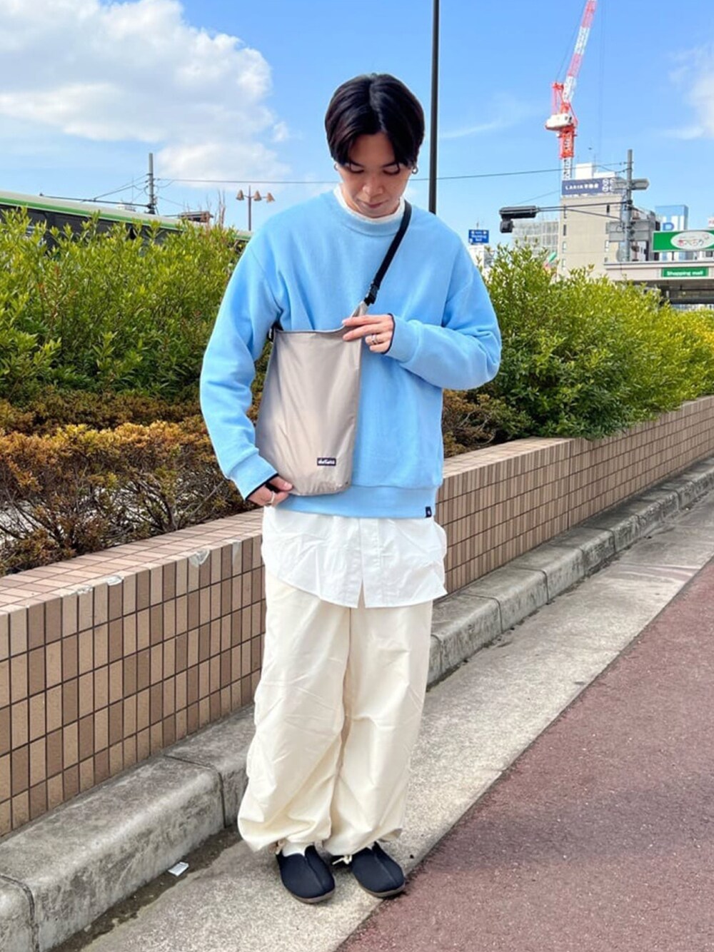 ブルー系のニット/セーター、ホワイト系のシャツ/ブラウス、グレー系のショルダーバッグを着用したメンズの春コーディネートの1枚目の写真