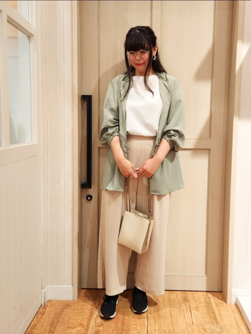 グリーン系のシャツ/ブラウス、ホワイト系のTシャツ/カットソー、ブラック系のスニーカーを着用したレディースの秋コーディネートの1枚目の写真