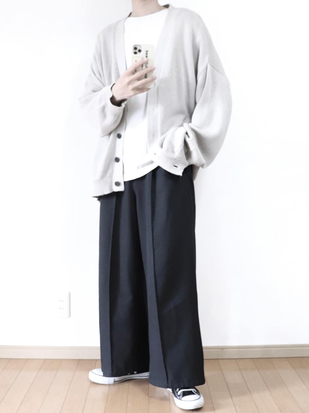 ベージュ系のカーディガン/ボレロ、グレー系のTシャツ/カットソー、ブラック系のスラックスを着用したメンズの春コーディネートの1枚目の写真