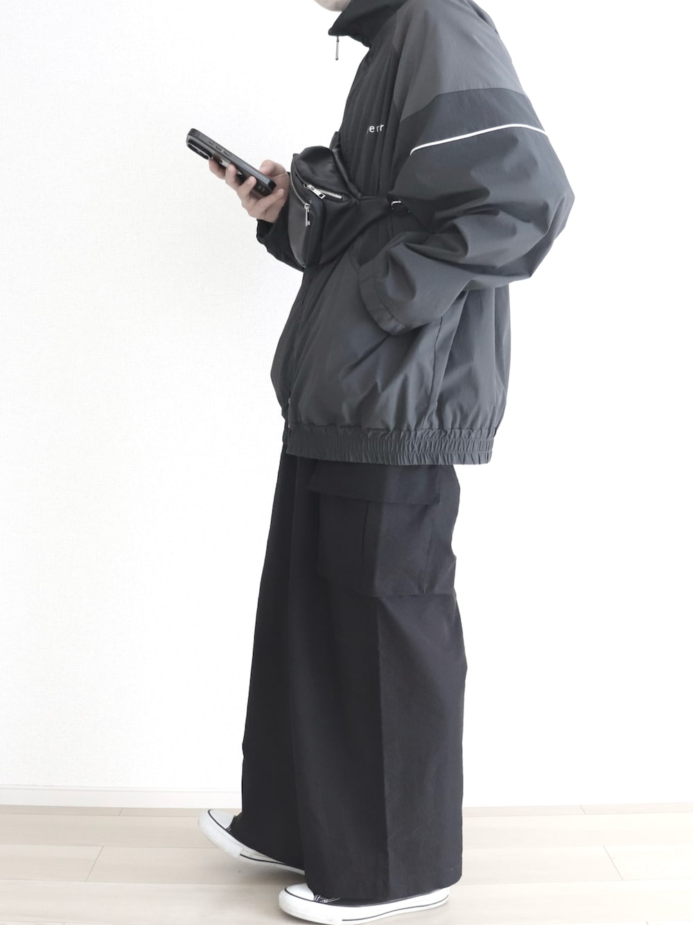 ブラック系のその他アウター、ブラック系のスニーカー、ブラック系のカーゴパンツを着用したメンズの秋コーディネートの1枚目の写真