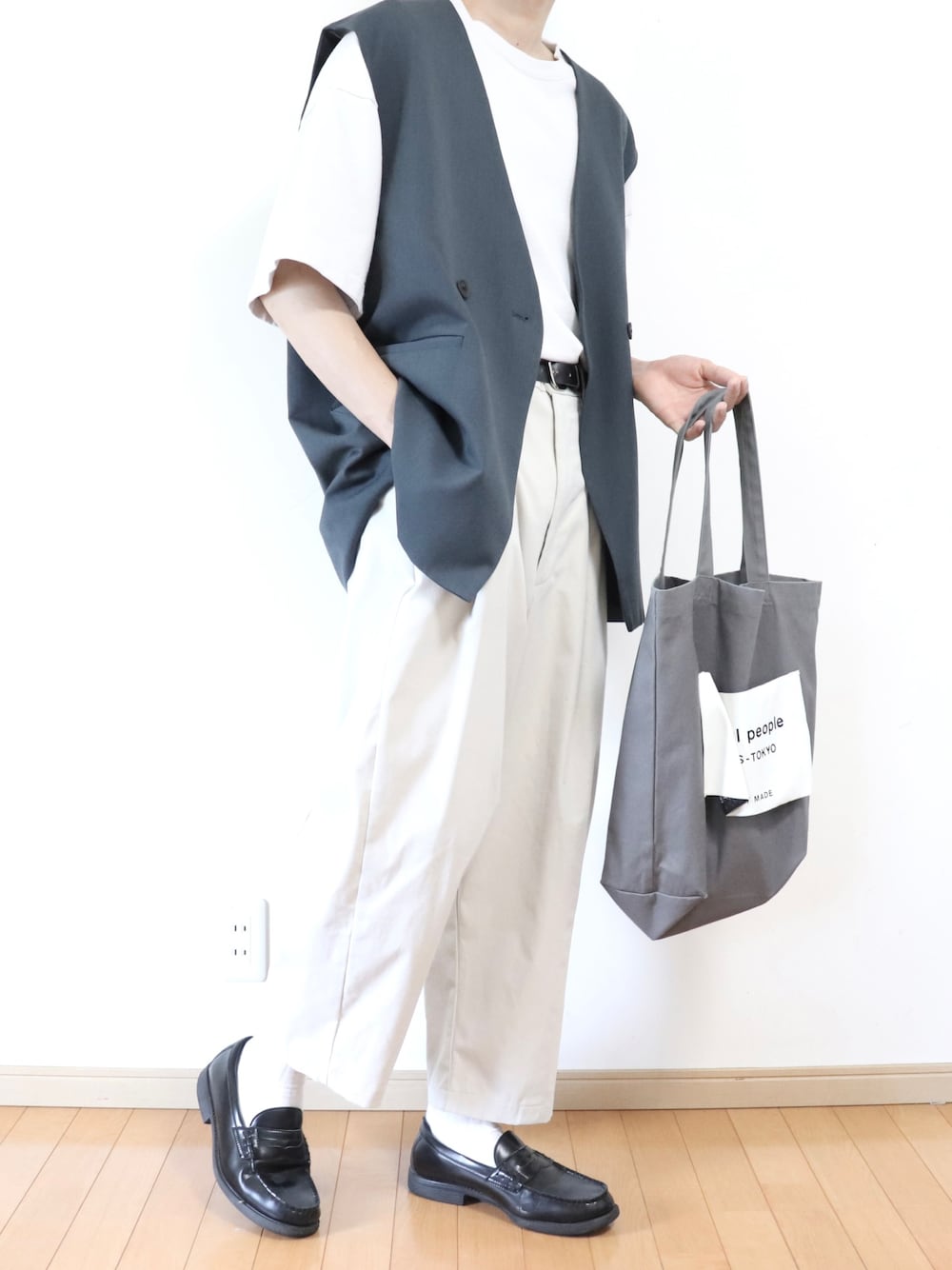 ブルー系のベスト、グレー系のトートバッグ、グレー系のTシャツ/カットソーを着用したメンズの夏コーディネートの1枚目の写真