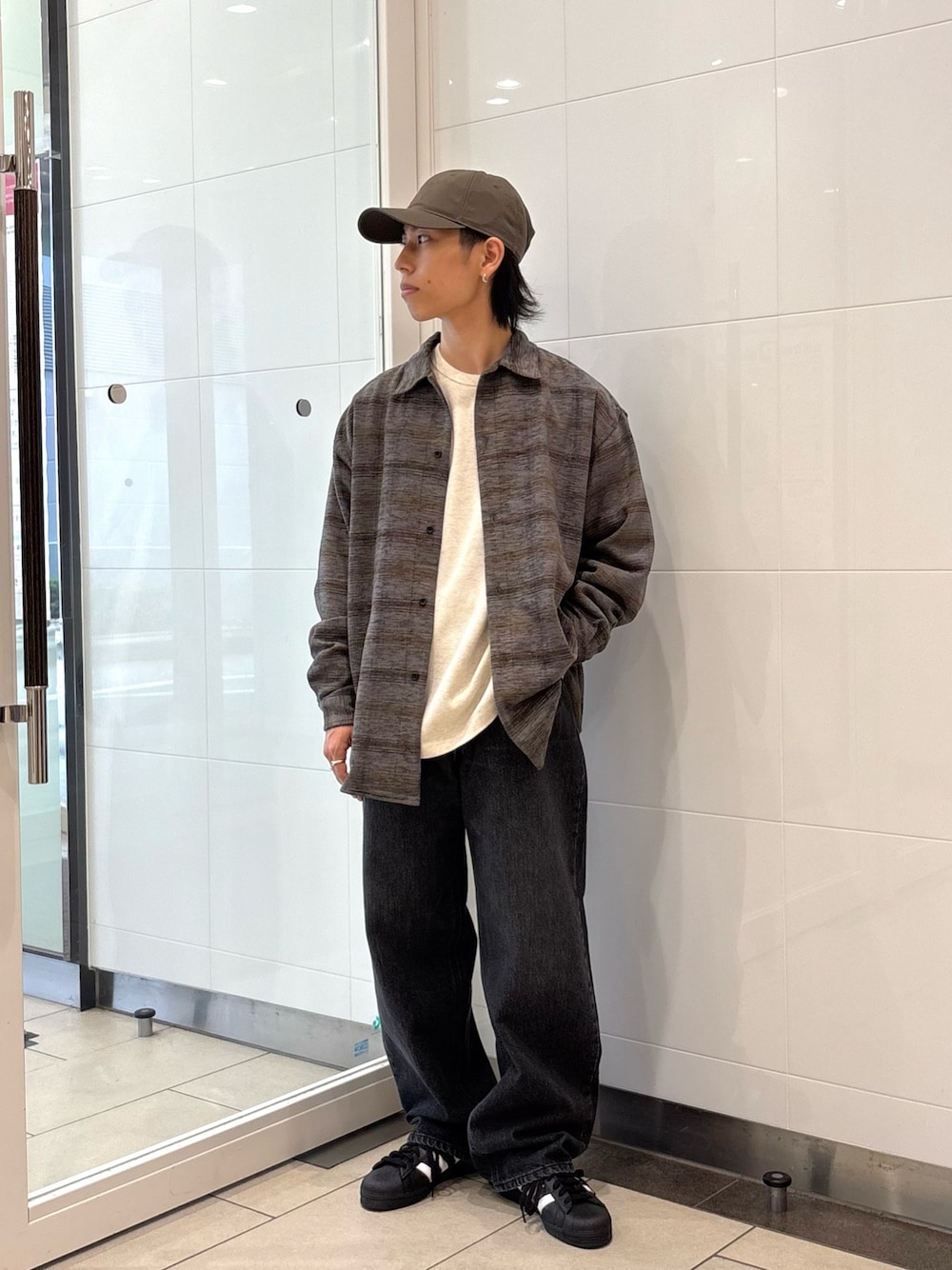 グレー系のシャツ/ブラウス、ベージュ系のTシャツ/カットソー、ブラック系のデニムパンツを着用したメンズの秋コーディネートの1枚目の写真