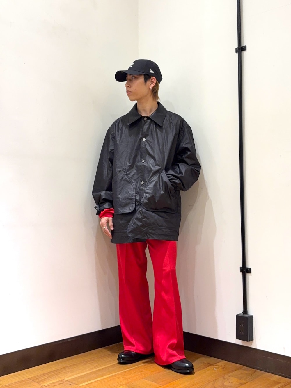 ブラック系のその他アウター、レッド系のその他パンツ、レッド系のニット/セーターを着用したメンズの冬コーディネートの1枚目の写真