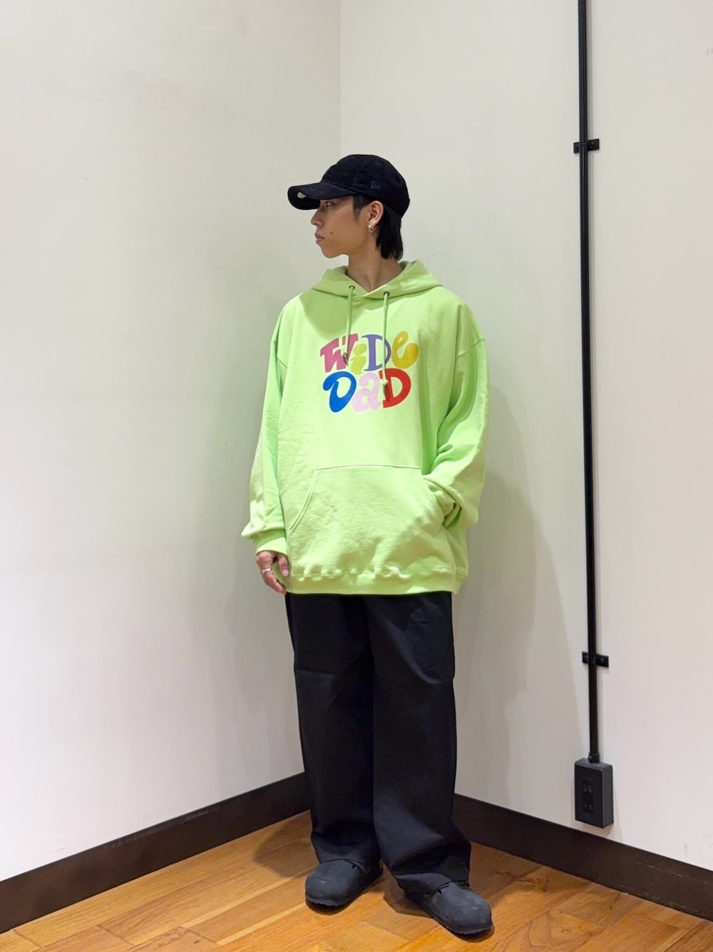 グリーン系のパーカー、ブラック系のその他パンツ、ブラック系のサンダルを着用したメンズの秋コーディネートの1枚目の写真