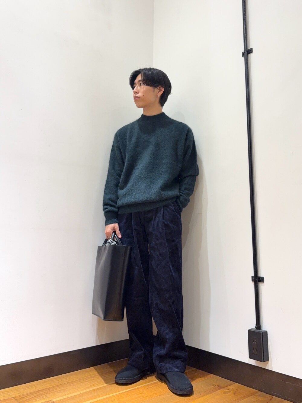 グリーン系のニット/セーター、グレー系のその他パンツ、ブラック系のトートバッグを着用したメンズの秋コーディネートの1枚目の写真