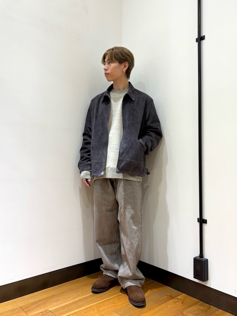 グレー系のブルゾン、グレー系のスウェット、ブラウン系のデニムパンツを着用したメンズの冬コーディネートの1枚目の写真