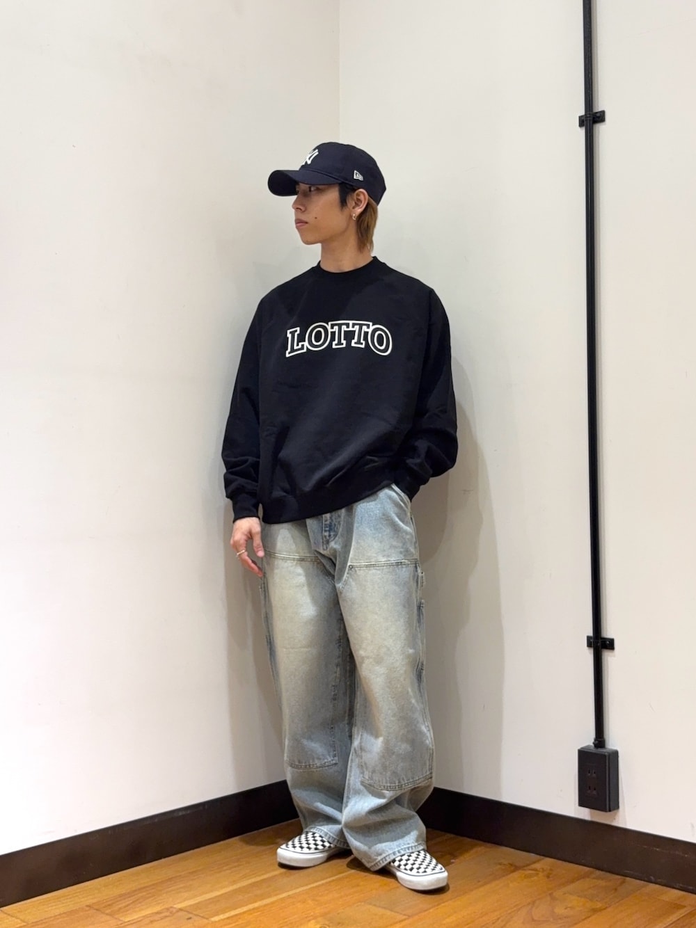 ブラック系のスウェット、ブルー系のデニムパンツ、ブルー系のキャップを着用したメンズの春コーディネートの1枚目の写真