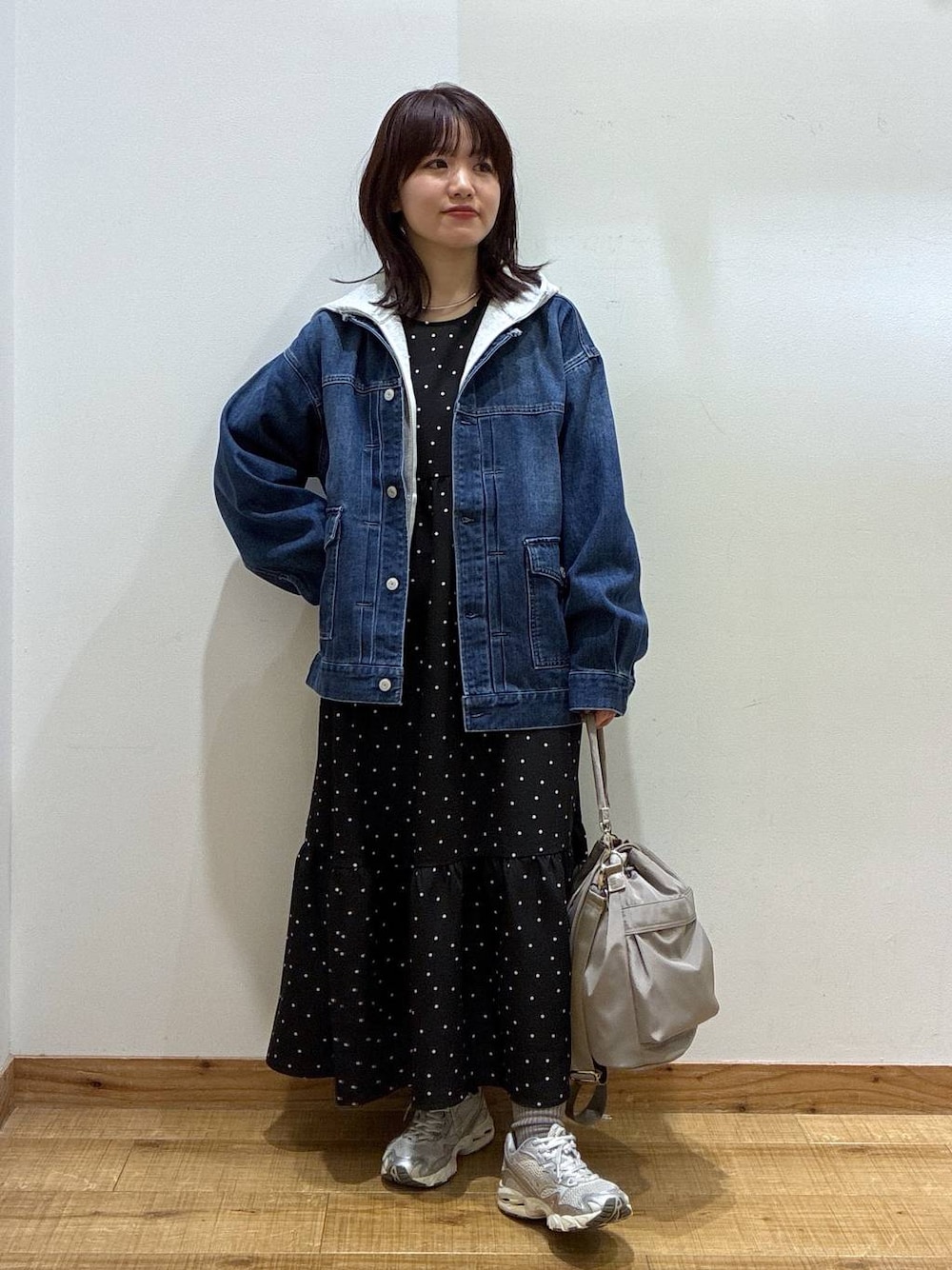 グレー系のショルダーバッグ、グレー系のパーカー、ブルー系のデニムジャケットを着用したレディースの冬コーディネートの1枚目の写真