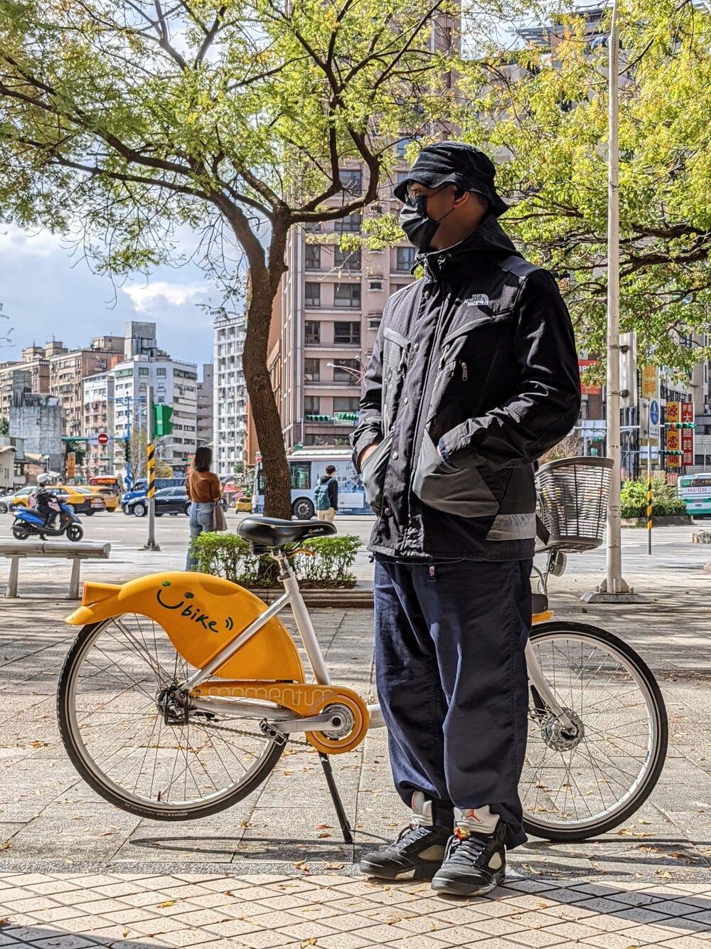 ブラック系のマウンテンパーカー、ブルー系のパンツ、ブラック系のスニーカーを着用したメンズの冬コーディネートの3枚目の写真