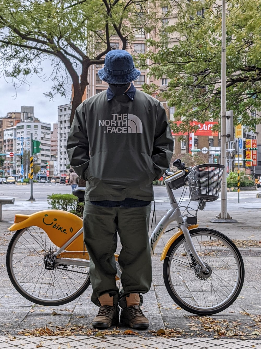 グリーン系のその他アウター、ブルー系のシャツ/ブラウス、グリーン系のチノパンツを着用したメンズの冬コーディネートの2枚目の写真