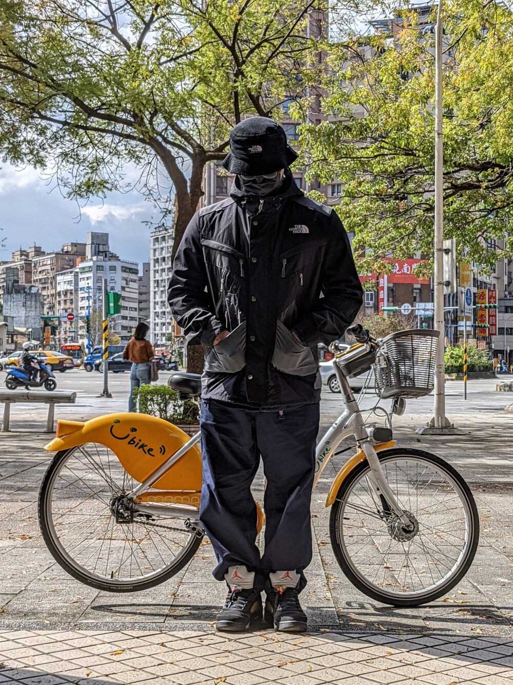 ブラック系のマウンテンパーカー、ブルー系のパンツ、ブラック系のスニーカーを着用したメンズの冬コーディネートの2枚目の写真