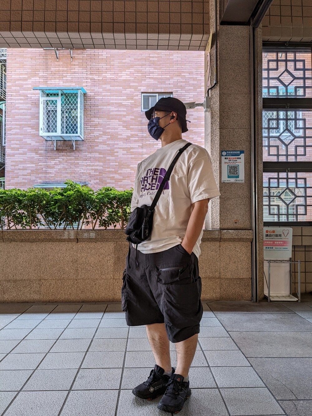 ブラック系のショルダーバッグ、ホワイト系のTシャツ/カットソー、グレー系のカーゴパンツを着用したメンズの春コーディネートの1枚目の写真