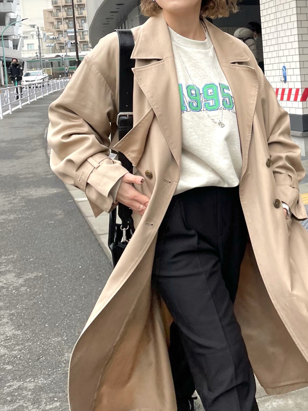 ベージュ系のトレンチコート、ブラック系のその他パンツ、ブラック系のショルダーバッグを着用したレディースの春コーディネートの2枚目の写真