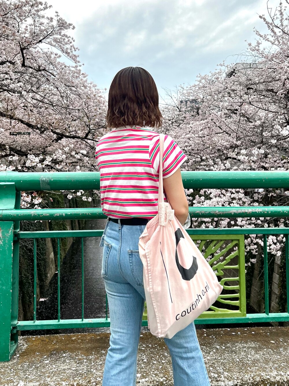 ブラック系のサンダル、ブルー系のデニムパンツ、ブルー系のデニムジャケットを着用したレディースの春コーディネートの3枚目の写真