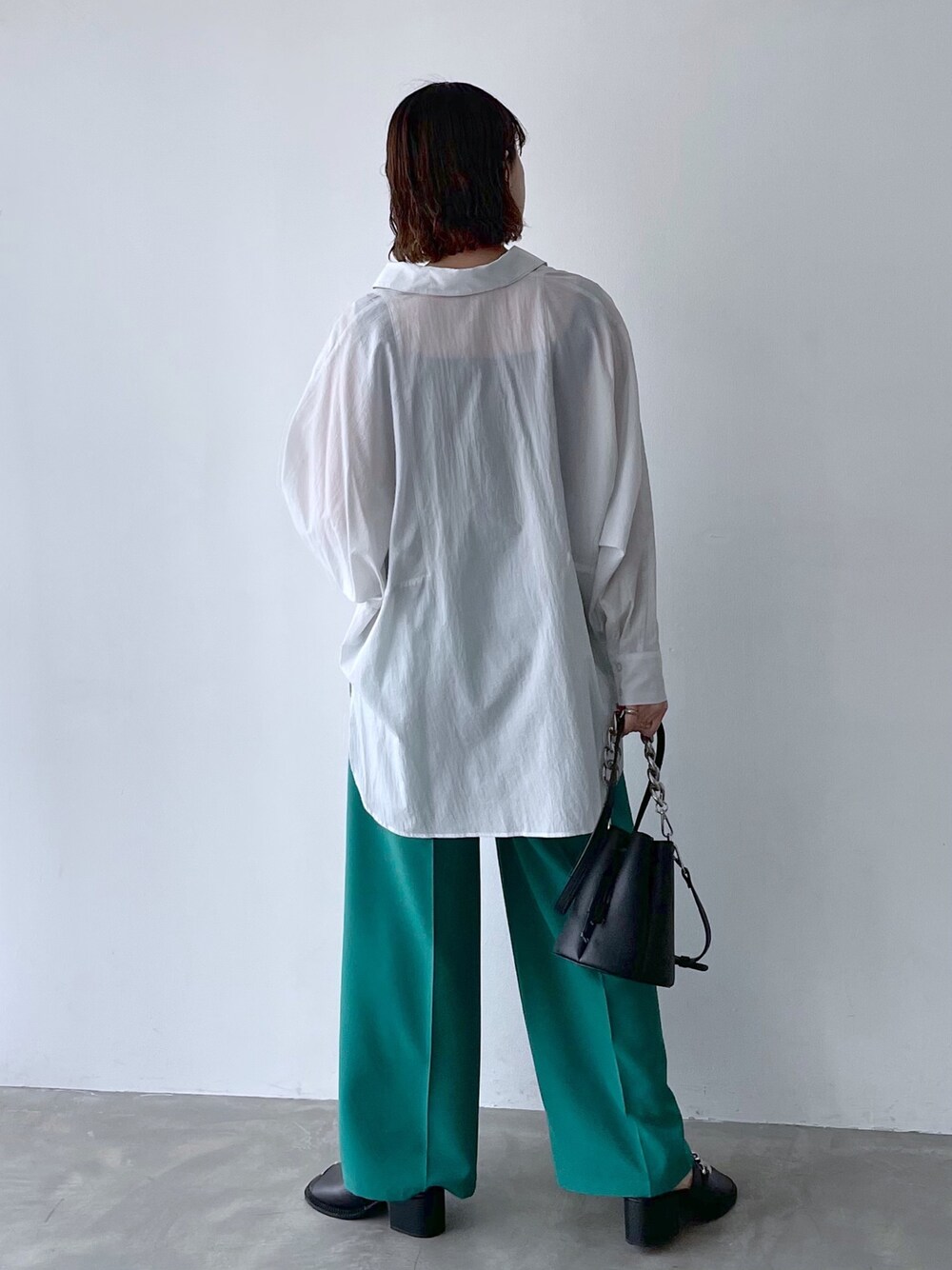 ホワイト系のシャツ/ブラウス、グリーン系のスラックス、シルバー系のネックレスを着用したレディースの春コーディネートの3枚目の写真