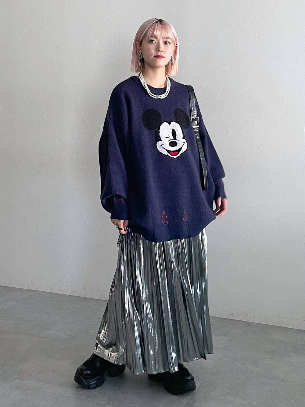 ブラック系のブーツ、ブラック系のショルダーバッグ、グレー系のスカートを着用したレディースの秋コーディネートの1枚目の写真