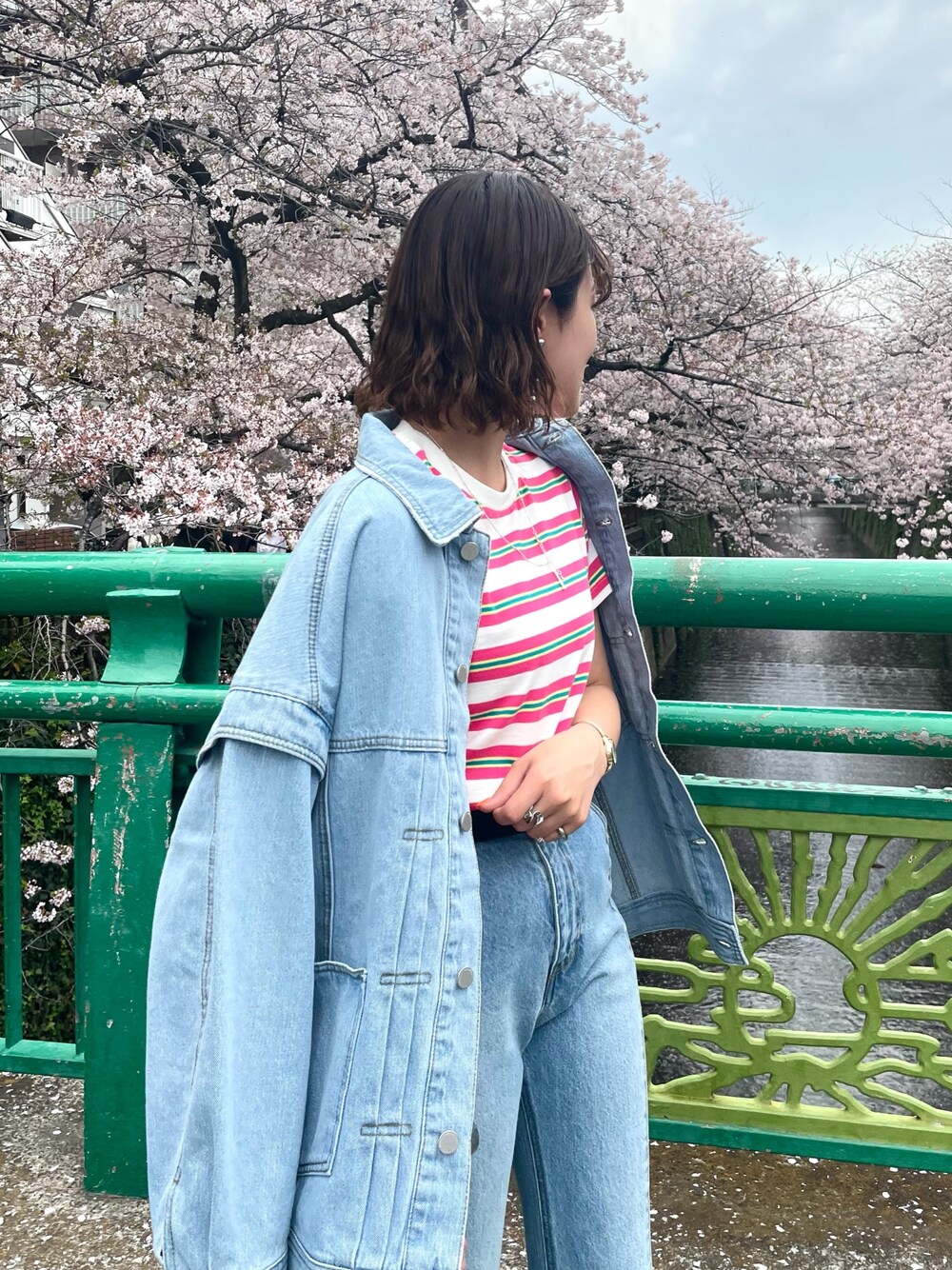 ブラック系のサンダル、ブルー系のデニムパンツ、ブルー系のデニムジャケットを着用したレディースの春コーディネートの2枚目の写真