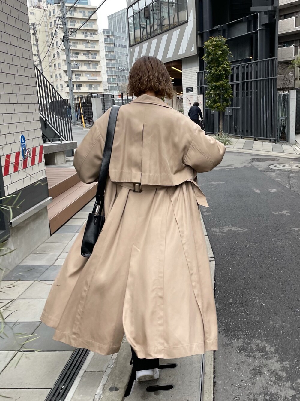 ベージュ系のトレンチコート、ブラック系のその他パンツ、ブラック系のショルダーバッグを着用したレディースの春コーディネートの3枚目の写真