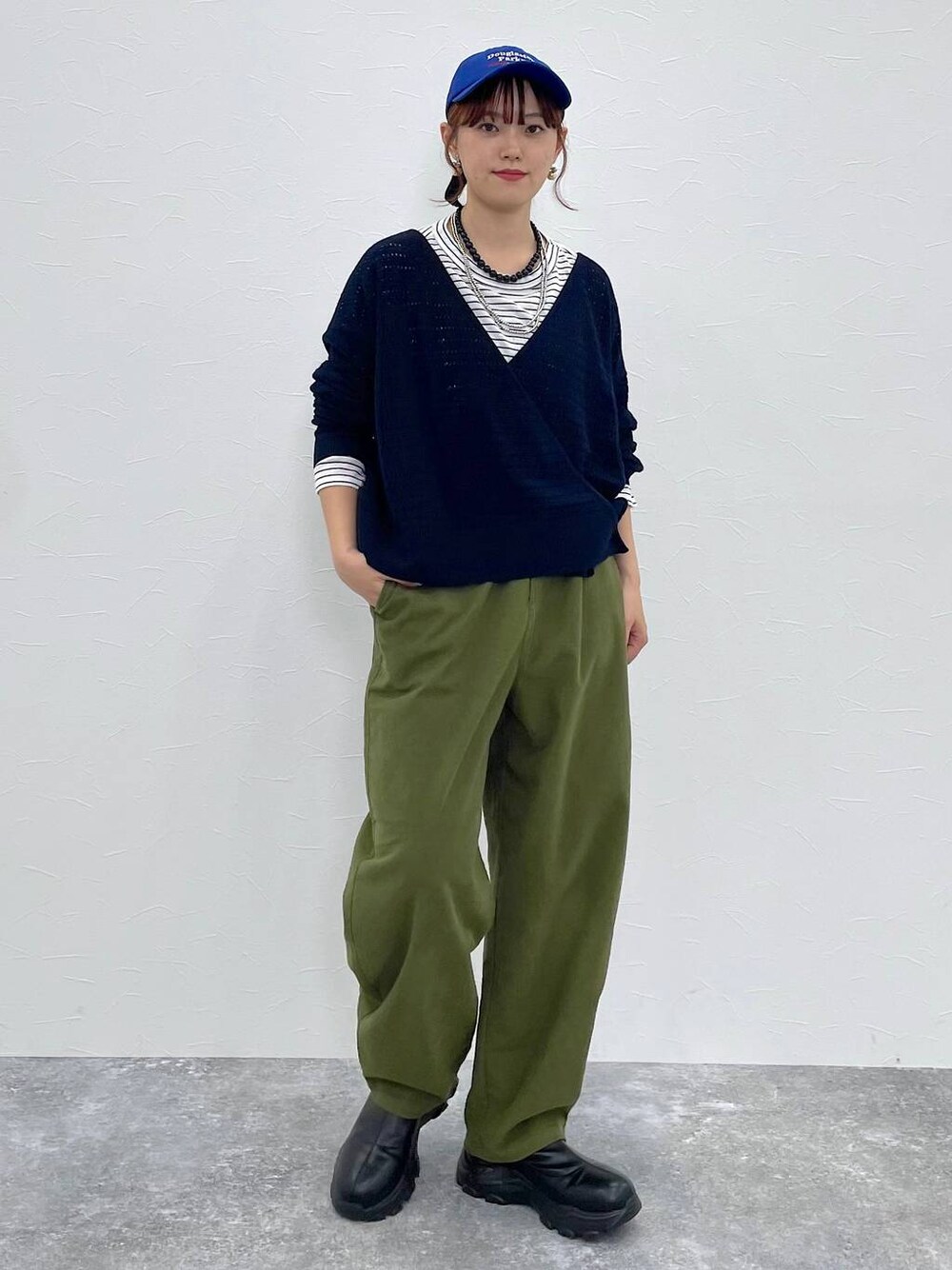 グリーン系のその他パンツ、ブラック系のブーツ、その他のTシャツ/カットソーを着用したレディースの秋コーディネートの1枚目の写真