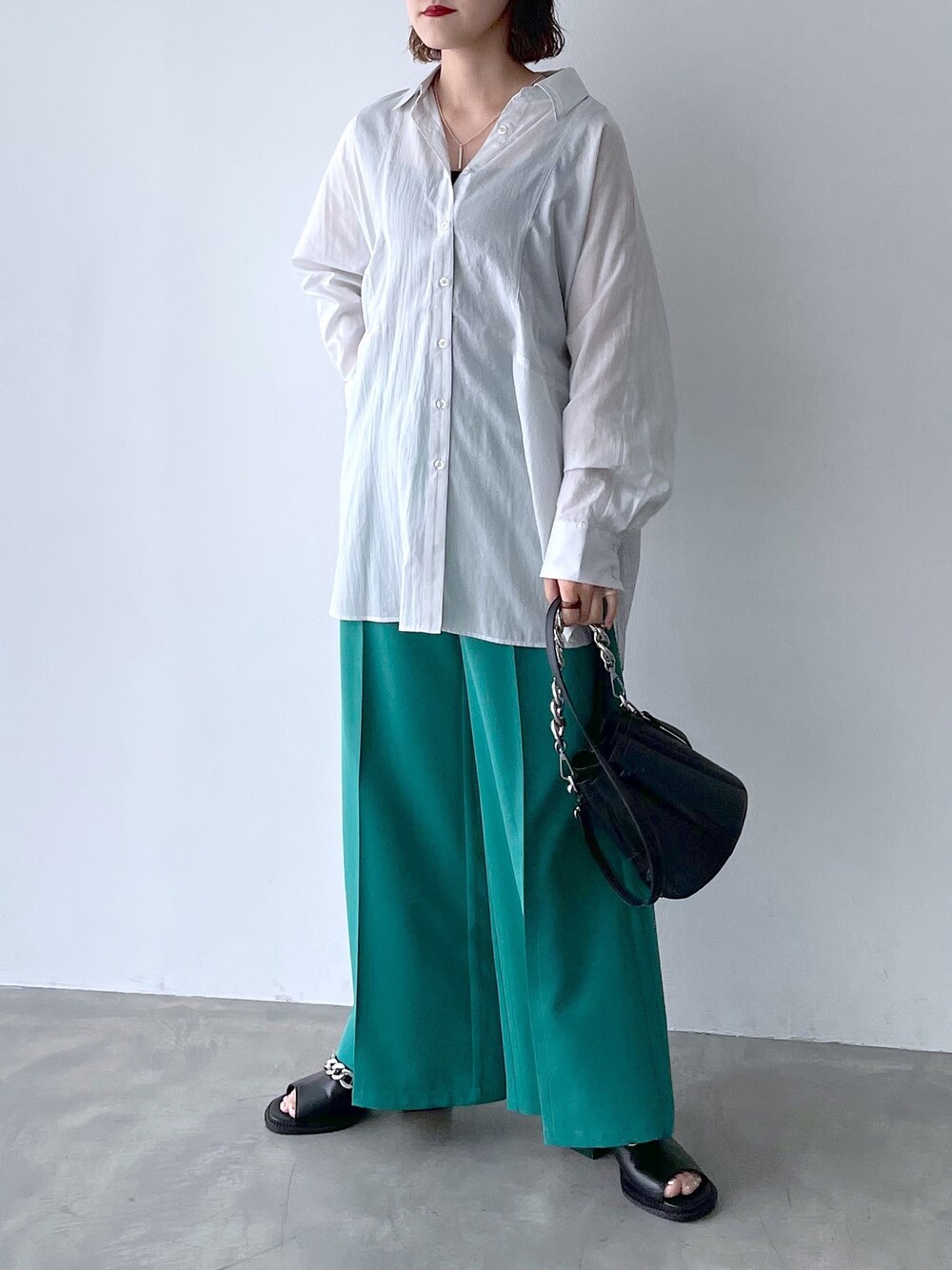 ホワイト系のシャツ/ブラウス、グリーン系のスラックス、シルバー系のネックレスを着用したレディースの春コーディネートの2枚目の写真