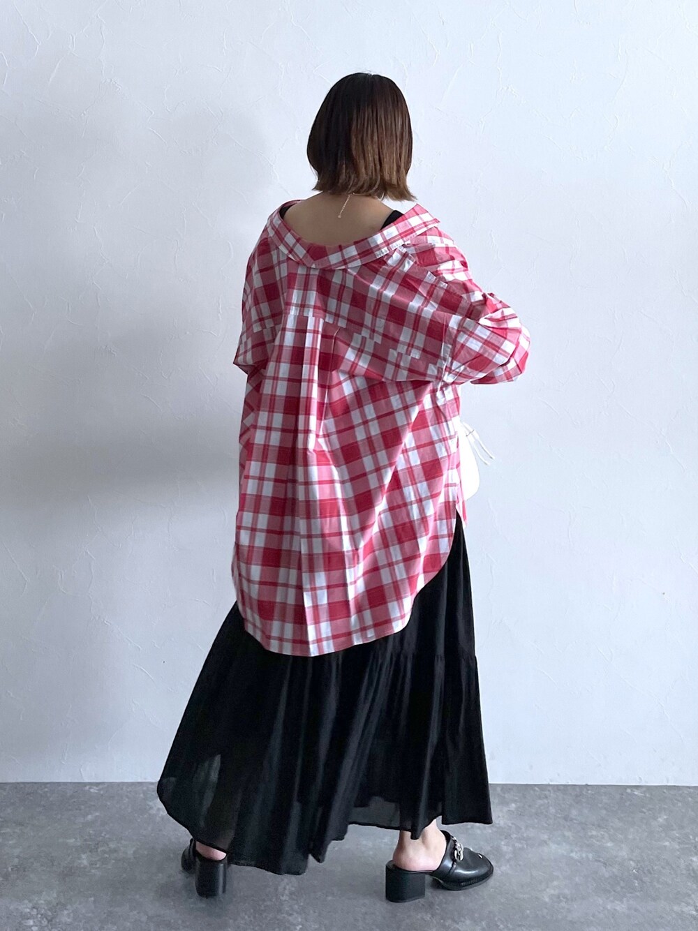 ブラック系のスカート、ブラック系のタンクトップ、レッド系のシャツ/ブラウスを着用したレディースの春コーディネートの2枚目の写真