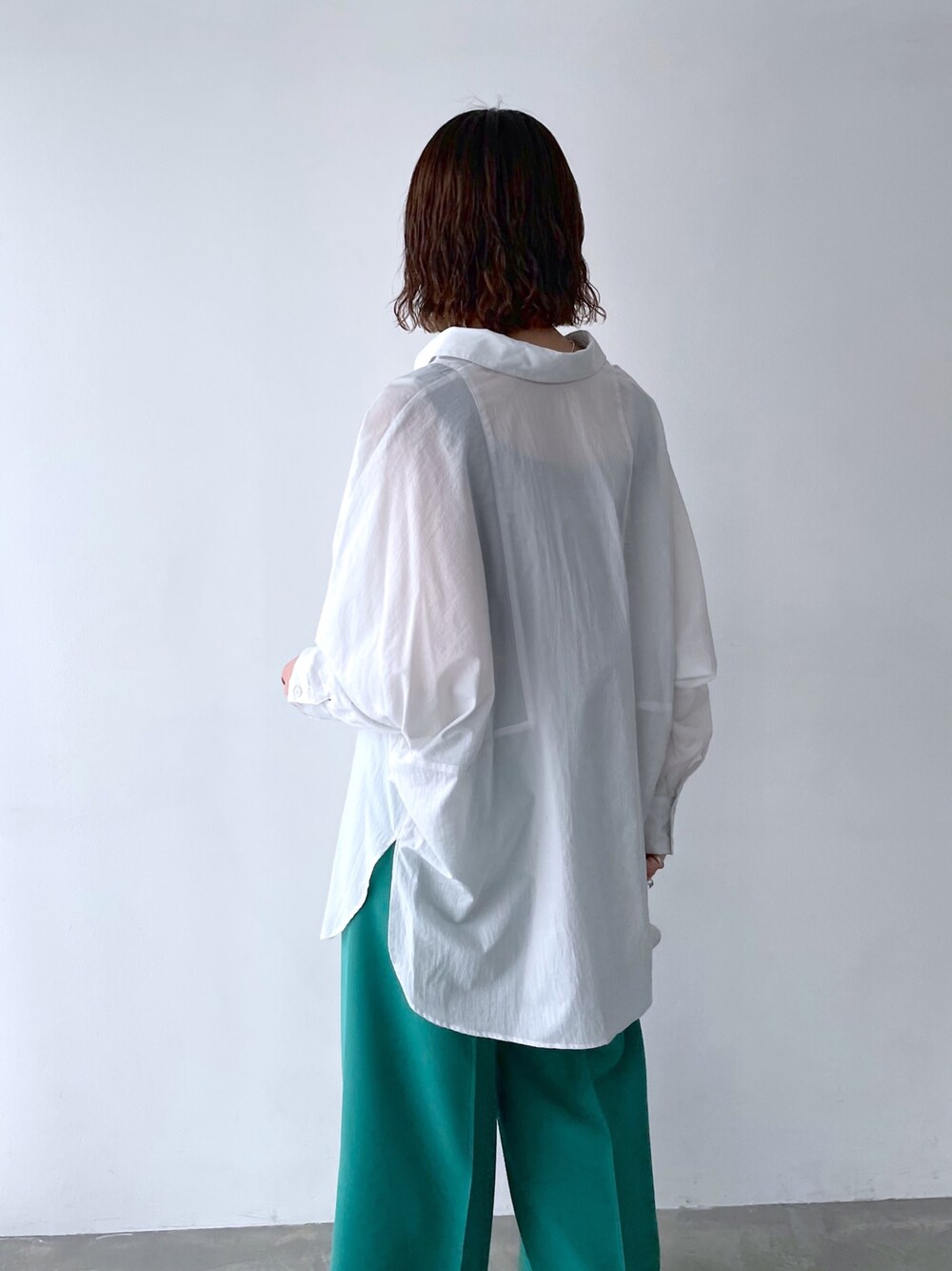 ホワイト系のシャツ/ブラウス、グリーン系のスラックス、シルバー系のネックレスを着用したレディースの春コーディネートの5枚目の写真