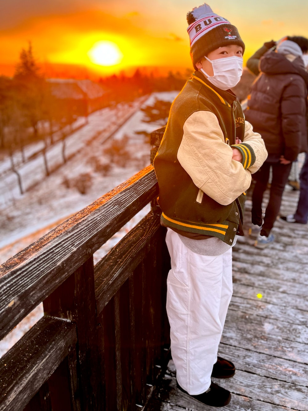 ブラック系のシューズ、ホワイト系のパンツ、グリーン系のスタジャンを着用したメンズの冬コーディネートの1枚目の写真