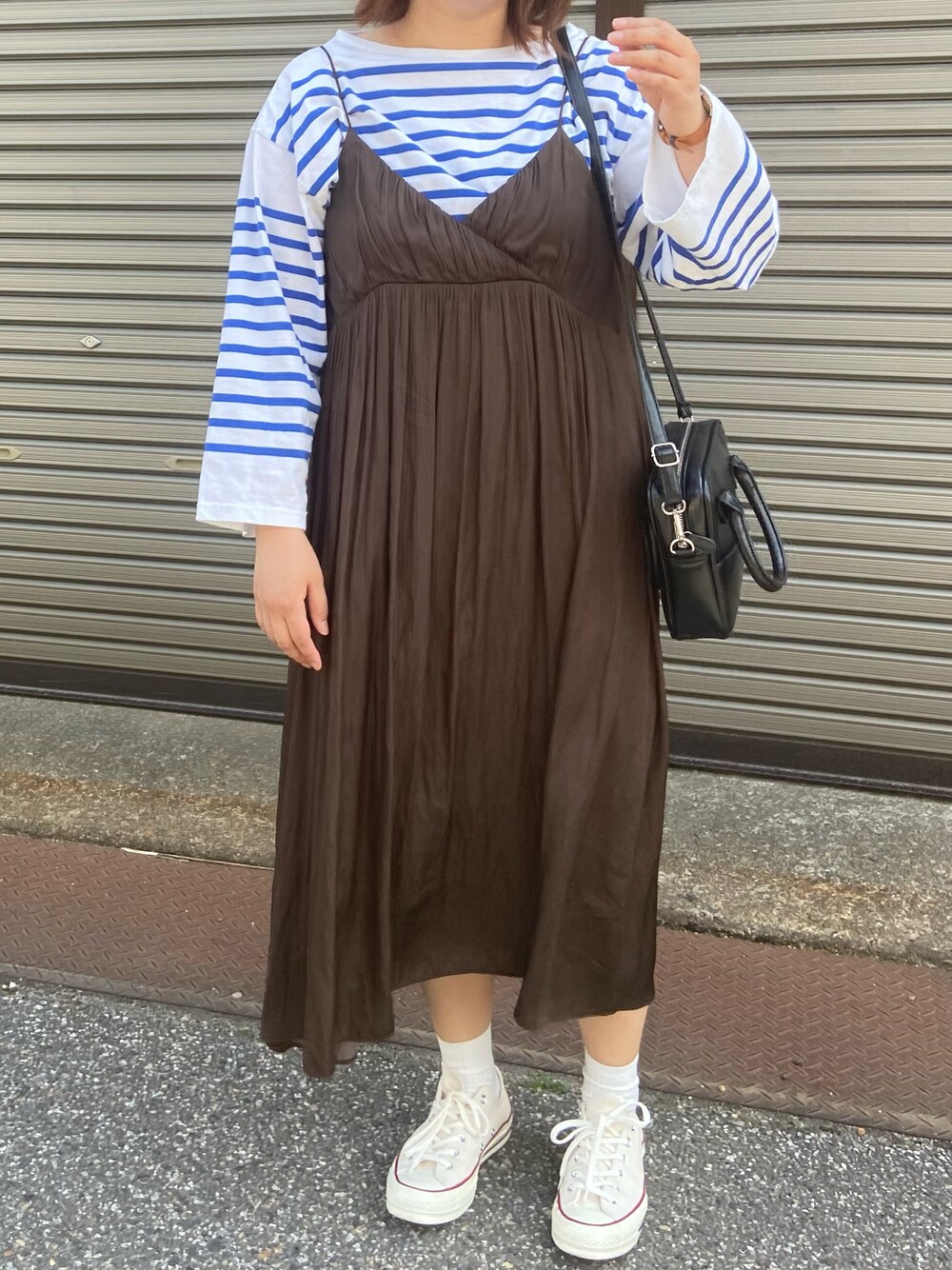 ブルー系のTシャツ/カットソー、ブラウン系のワンピース、ブラック系のショルダーバッグを着用したレディースの春コーディネートの1枚目の写真