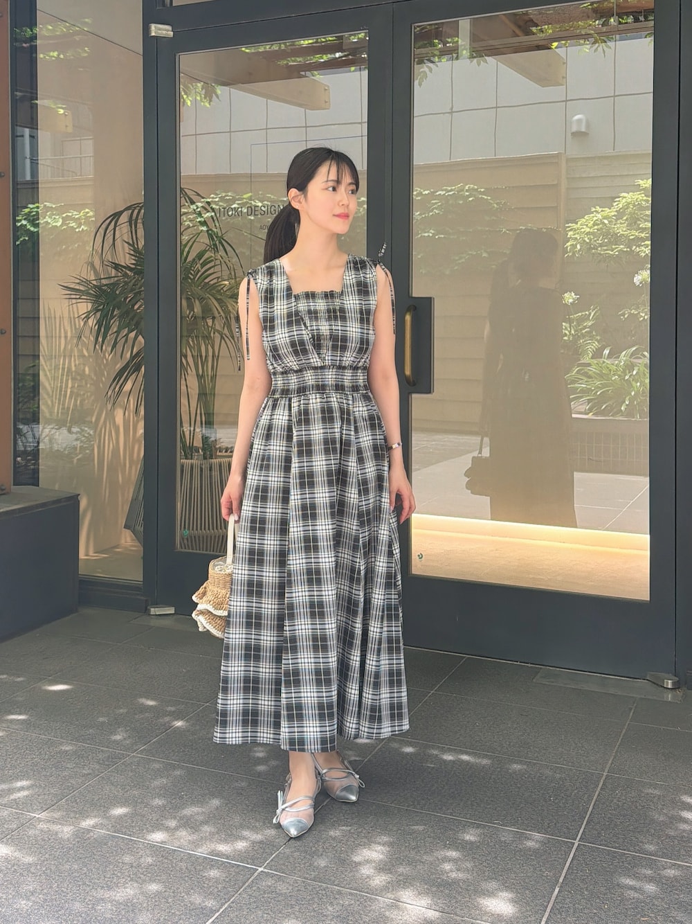 ブラック系のワンピース、シルバー系のパンプス、ベージュ系のショルダーバッグを着用したレディースの夏コーディネートの1枚目の写真