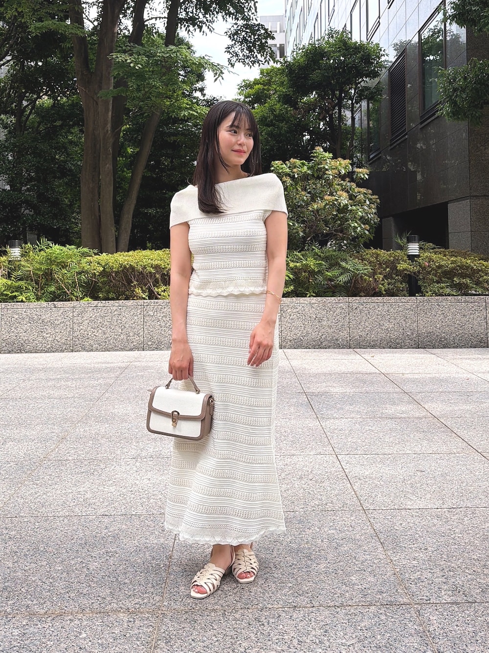 ホワイト系のワンピース、ホワイト系のパンプス、グレー系のショルダーバッグを着用したレディースの夏コーディネートの1枚目の写真