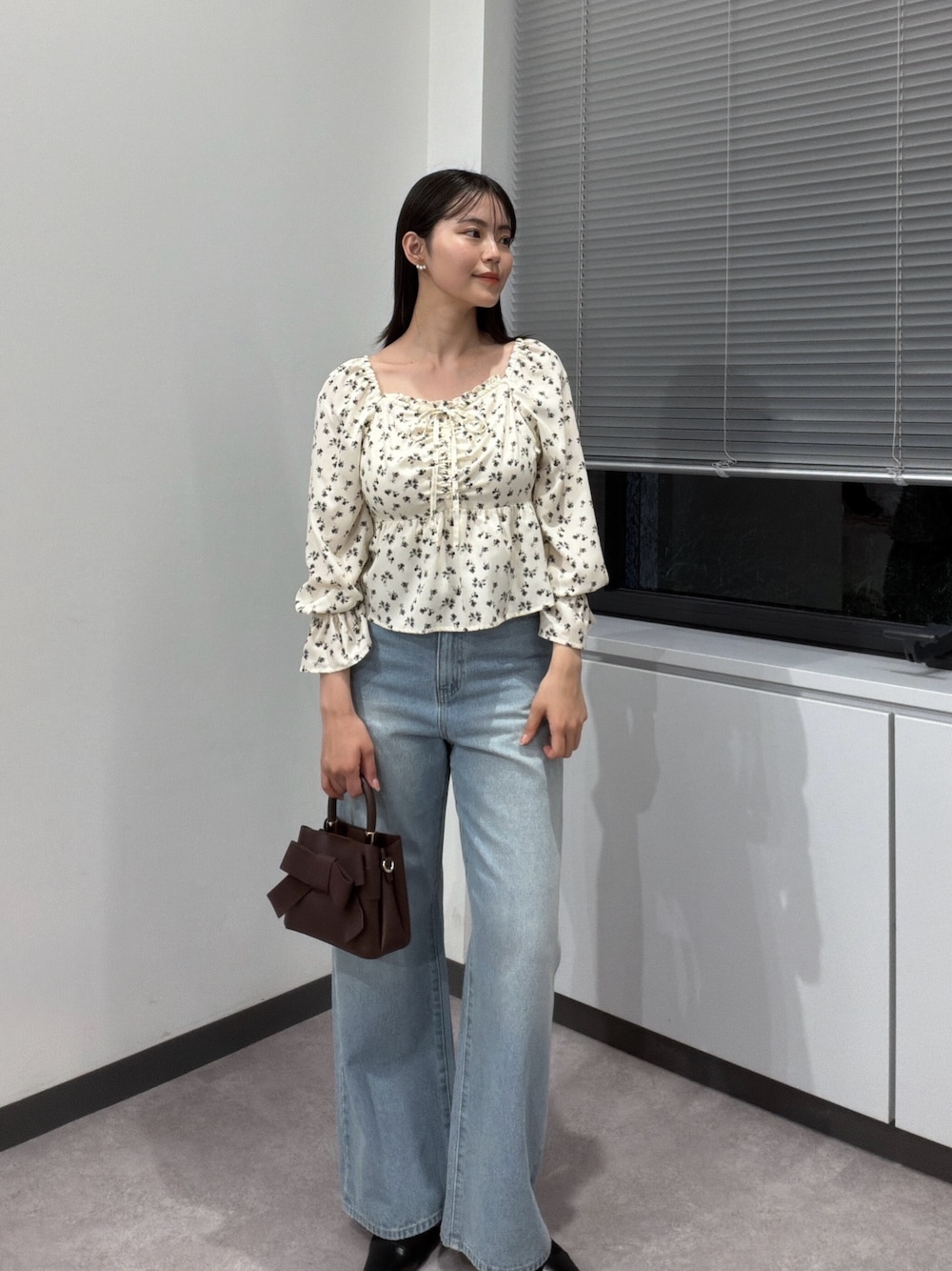 ホワイト系のシャツ/ブラウス、ブラウン系のショルダーバッグ、ブルー系のデニムパンツを着用したレディースの秋コーディネートの1枚目の写真